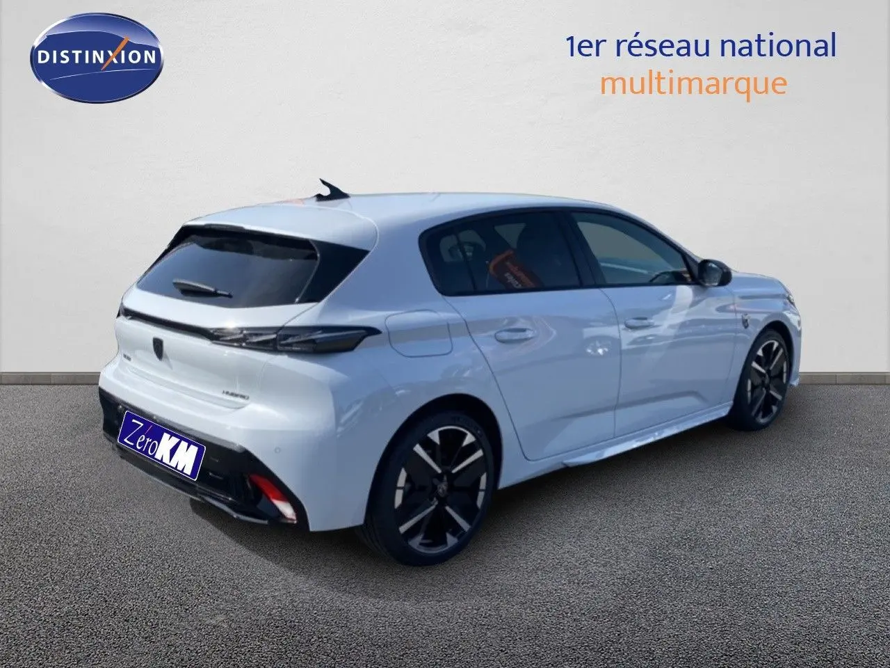 Peugeot 308 blanc Okenite métal en 3/4 arrière droit, jantes noires et vitres teintées visibles.