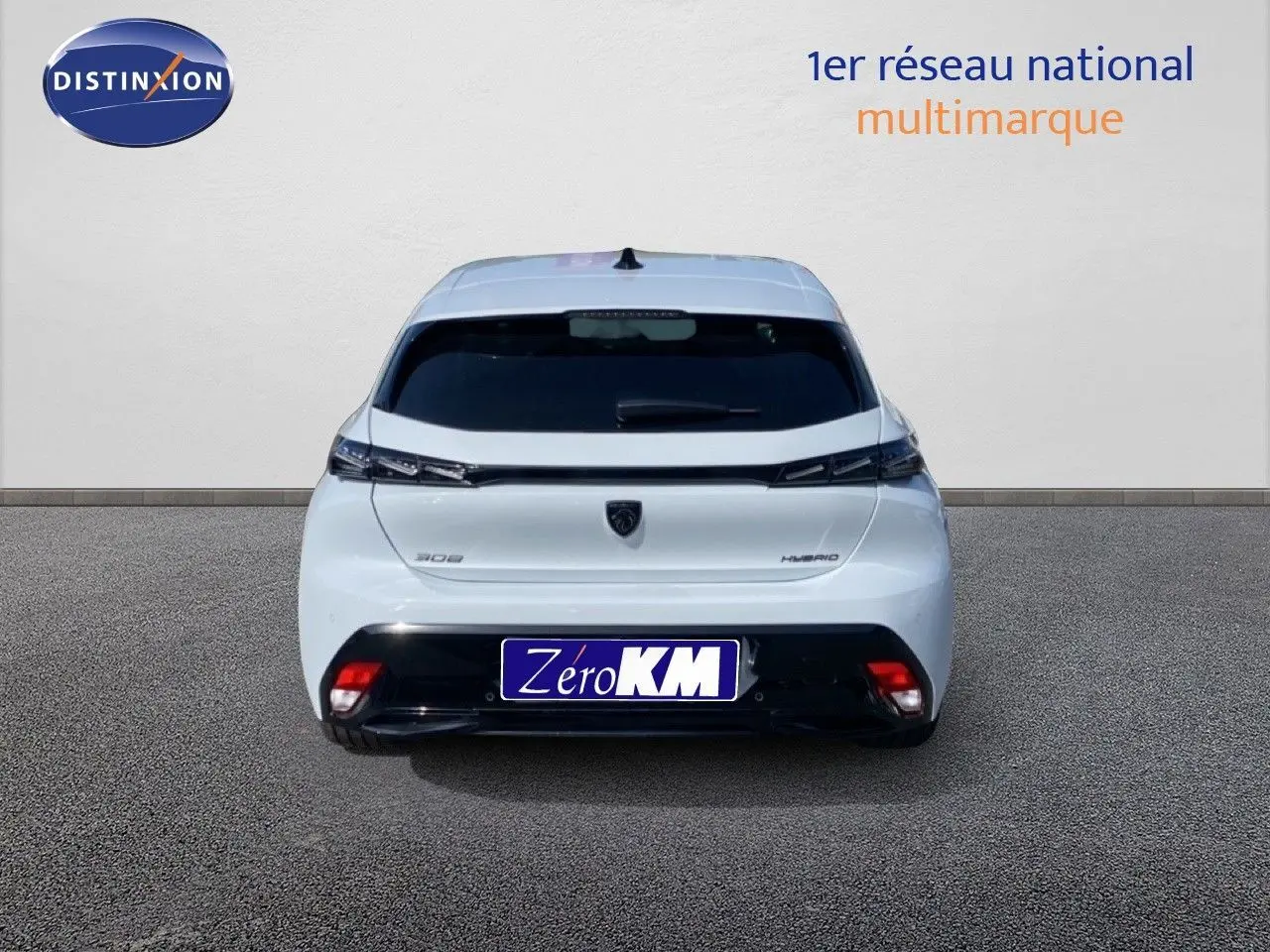 Vue arrière d'une Peugeot 308 blanche Okenite Metal, version hybride 2026, avec feux arrière fins et plaque Zéro KM.
