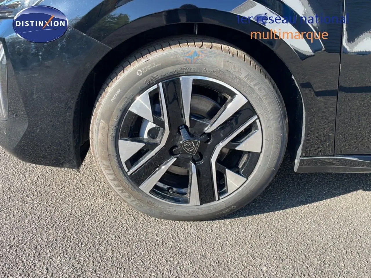 Gros plan sur la roue avant gauche noire et argentée d'une Peugeot 208 Hybrid 110ch Allure noir Perla Metal.
