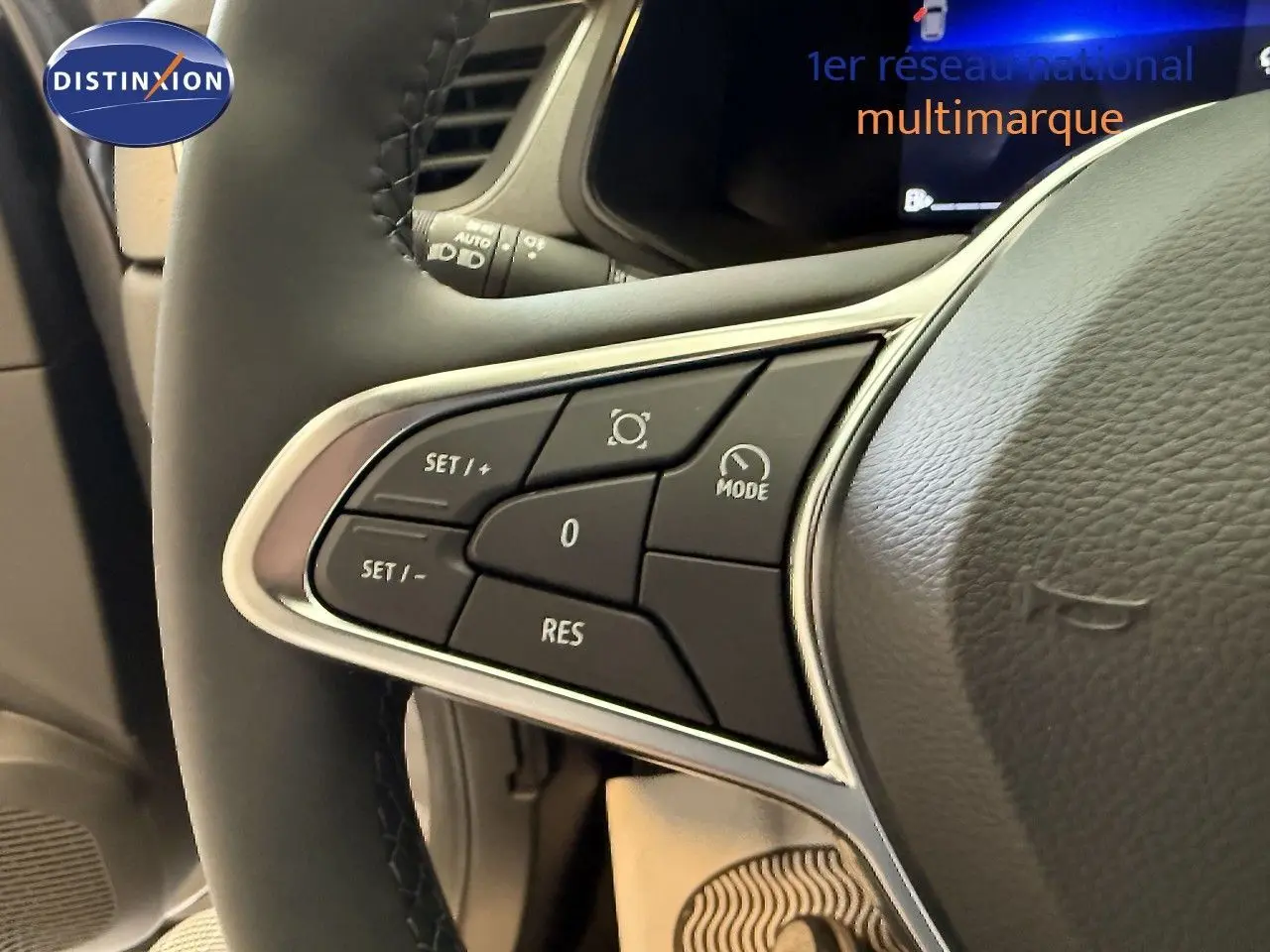 Gros plan sur les commandes au volant à gauche du Renault Captur gris Cassiopée, mettant en valeur les boutons de réglage.