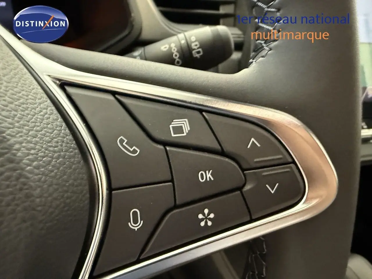 Gros plan sur les commandes multifonctions à droite du volant du Renault Captur gris Cassiopée, boutons noirs avec icônes blanches.