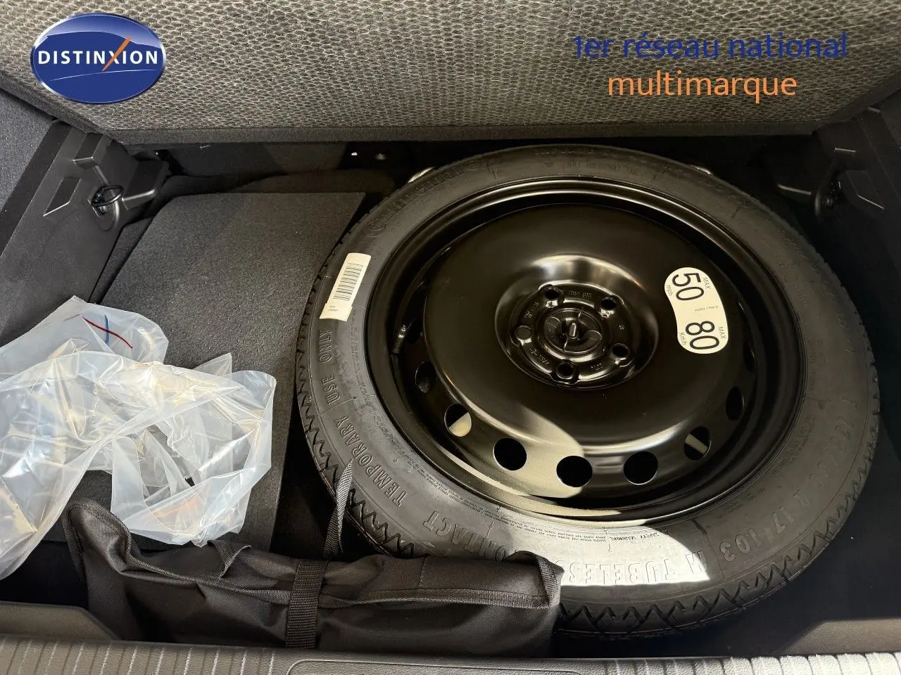 Gros plan sur la roue de secours noire dans le coffre d’un Renault Captur gris Cassiopée Métal 2025.