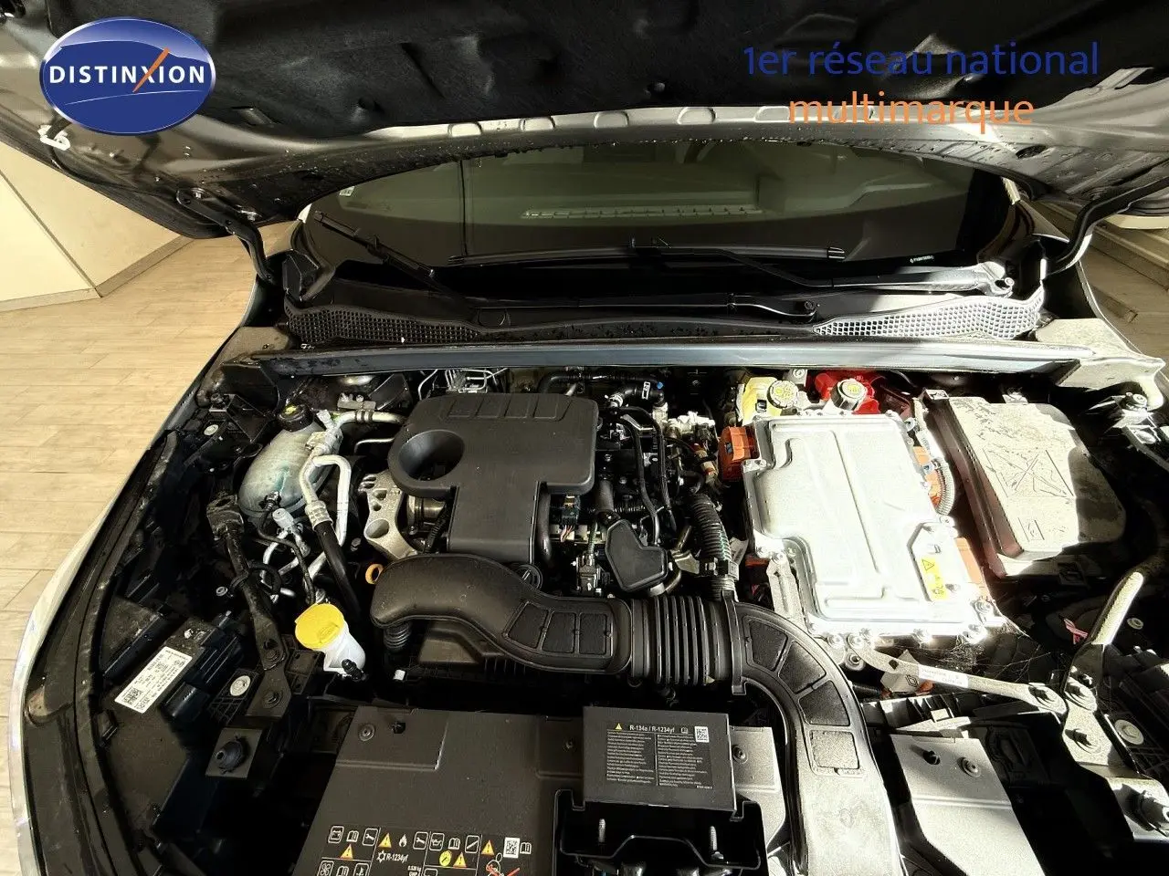 Moteur hybride Renault Captur 1.6 E-Tech 2025 vu de dessus, compartiment moteur ouvert, détails techniques visibles.