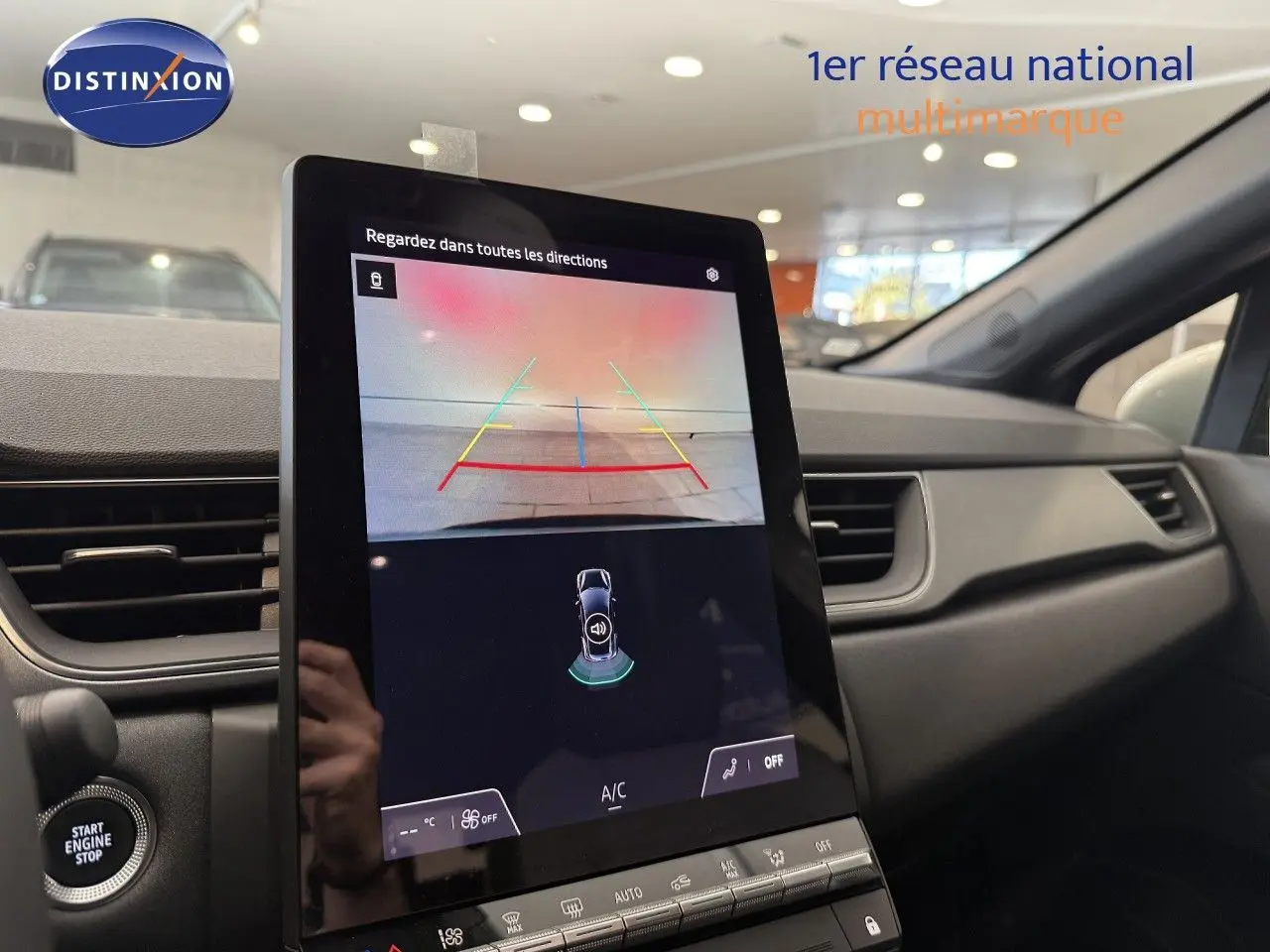 Vue intérieure du tableau de bord du Renault Captur 2025, écran tactile affichant la caméra de recul et commandes climatisation.