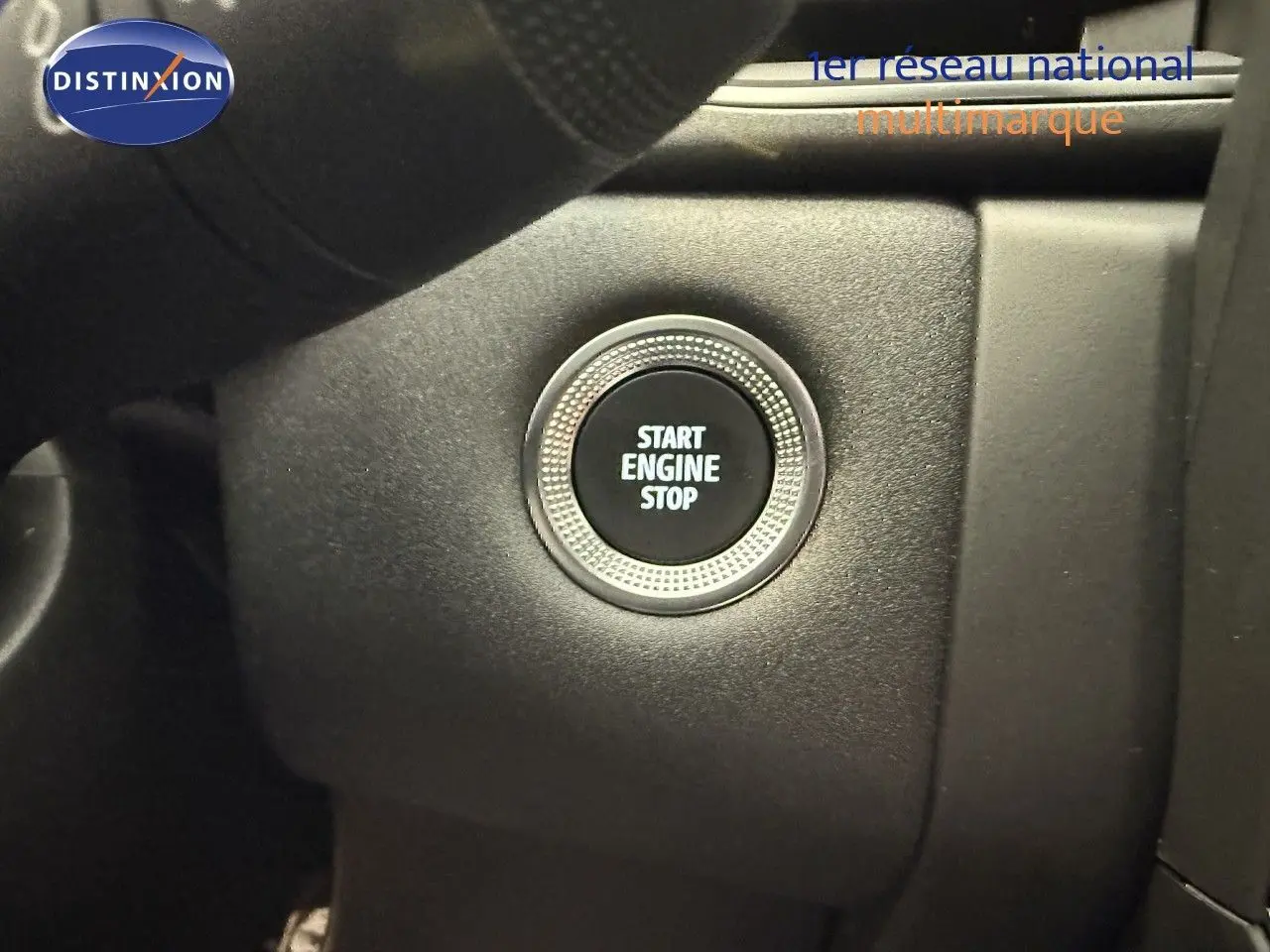 Bouton start engine stop en gros plan sur le tableau de bord d'une Renault Captur gris cassiopée métal 2025.