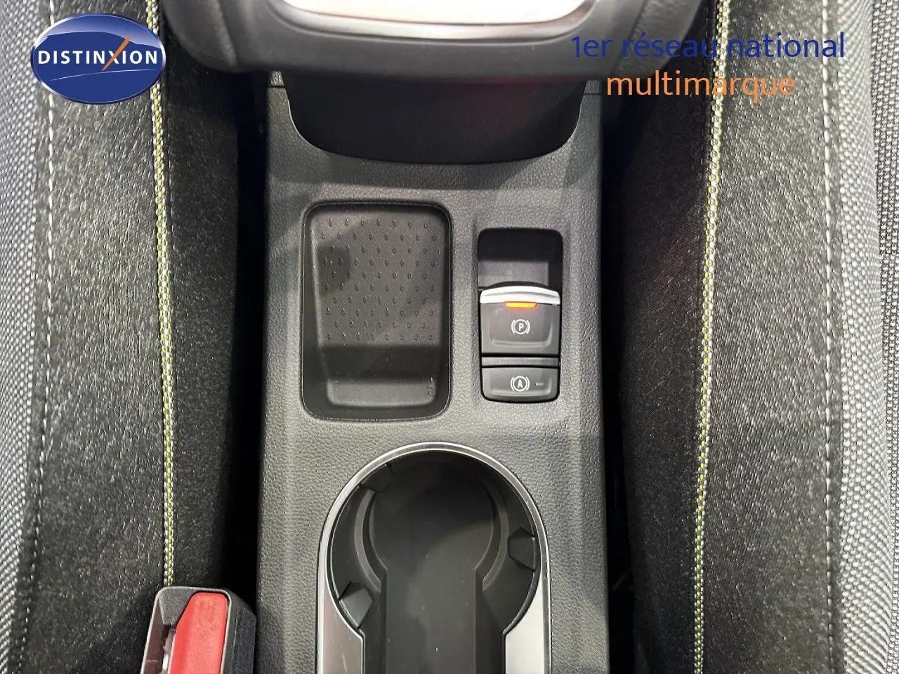 Gros plan sur la console centrale avec porte-gobelet et boutons de frein à main électronique du Renault Captur gris.