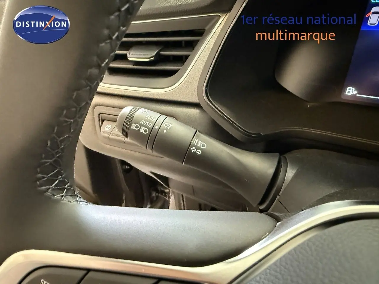 Détail du commodo d'éclairage à gauche du volant dans l'habitacle du Renault Captur gris Cassiopée 2025.