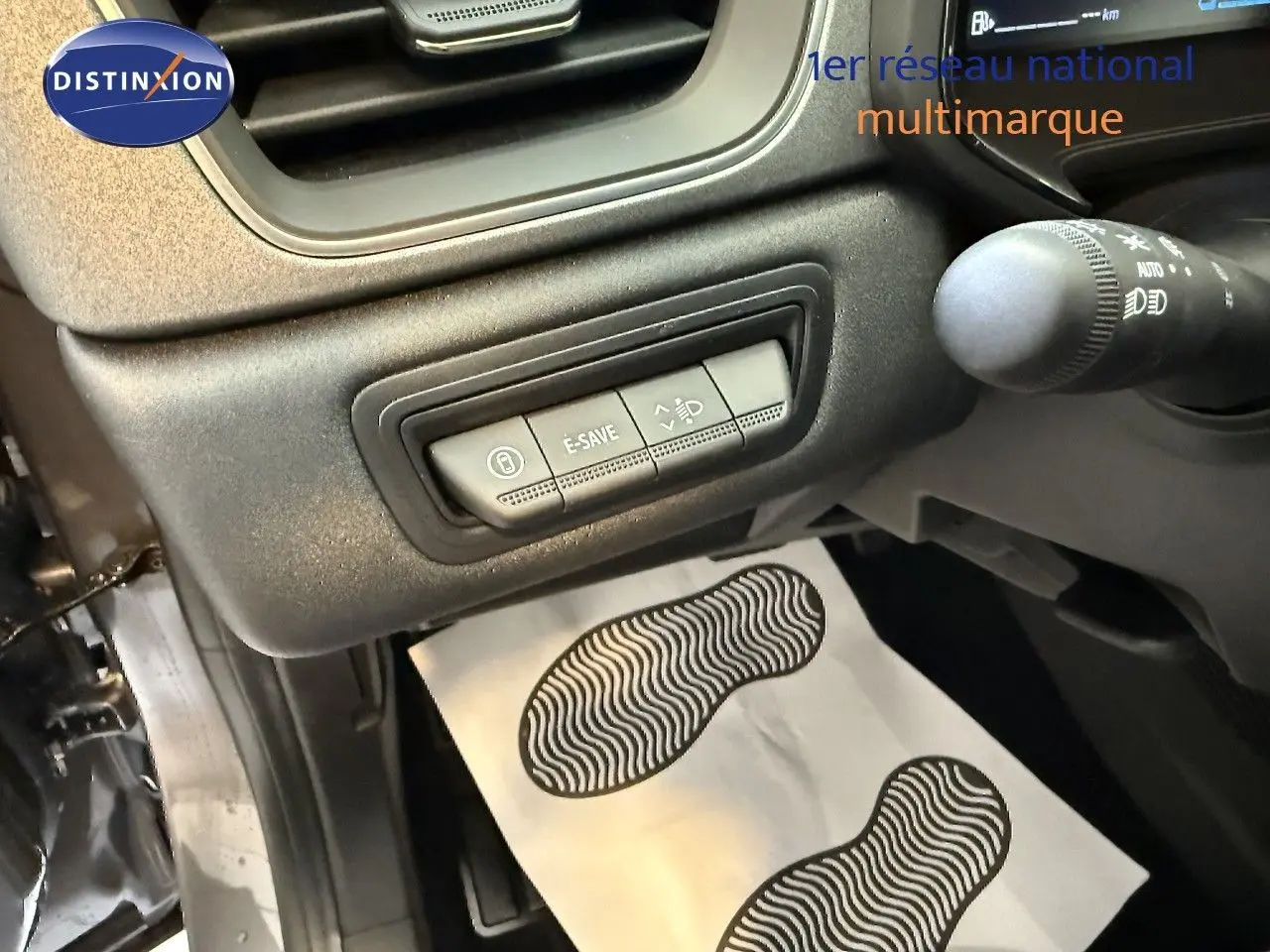 Vue rapprochée du tableau de bord côté gauche du Renault Captur gris cassiopée, montrant les commandes E-SAVE et réglage des phares.