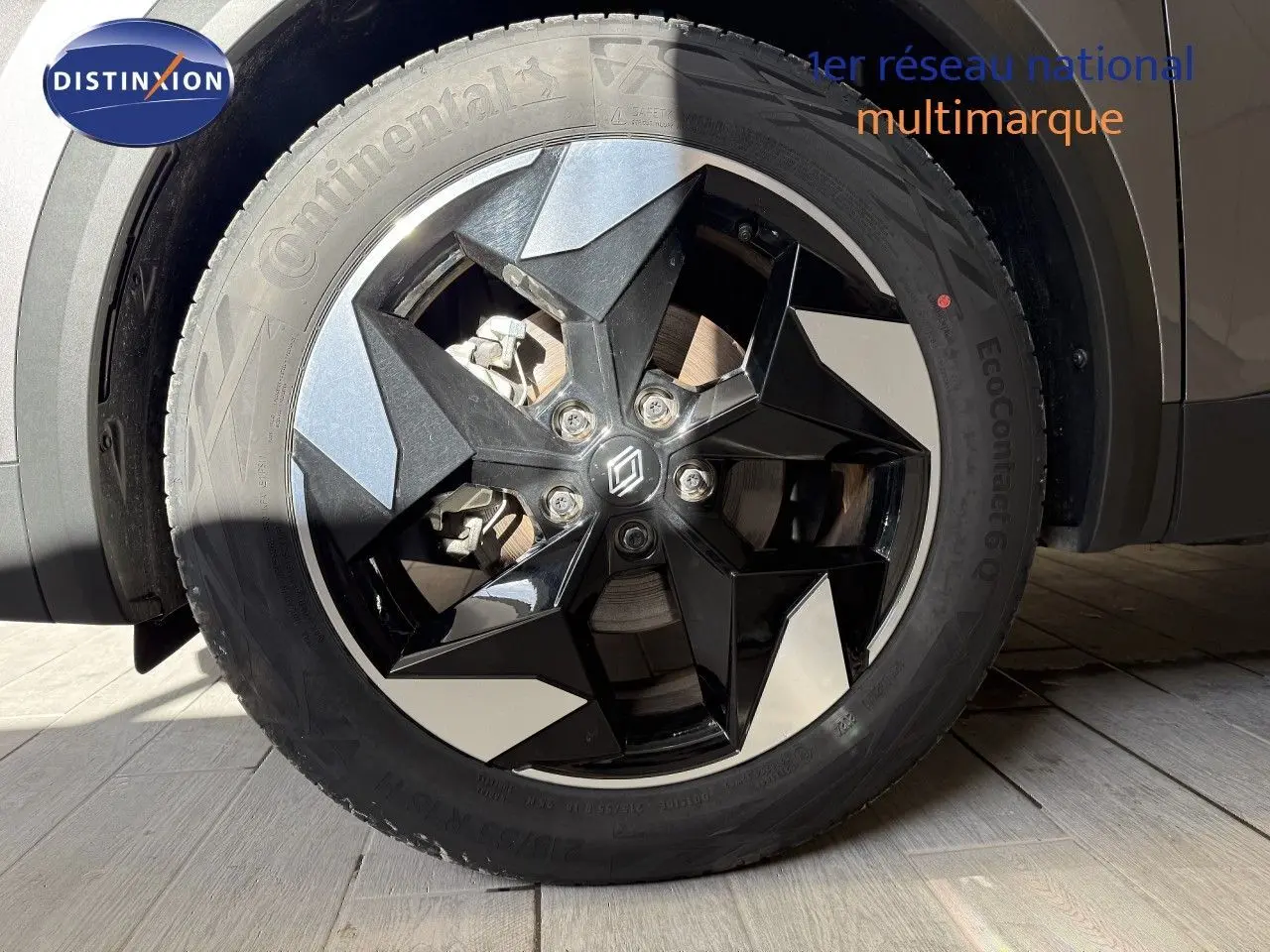 Gros plan sur la roue avant droite du Renault Captur gris cassiopée métal avec jante noire et argentée en 18 pouces.