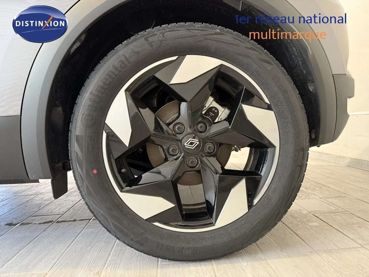 Gros plan sur la roue avant droite du Renault Captur gris Cassiopée avec jante noire et argentée au design géométrique.