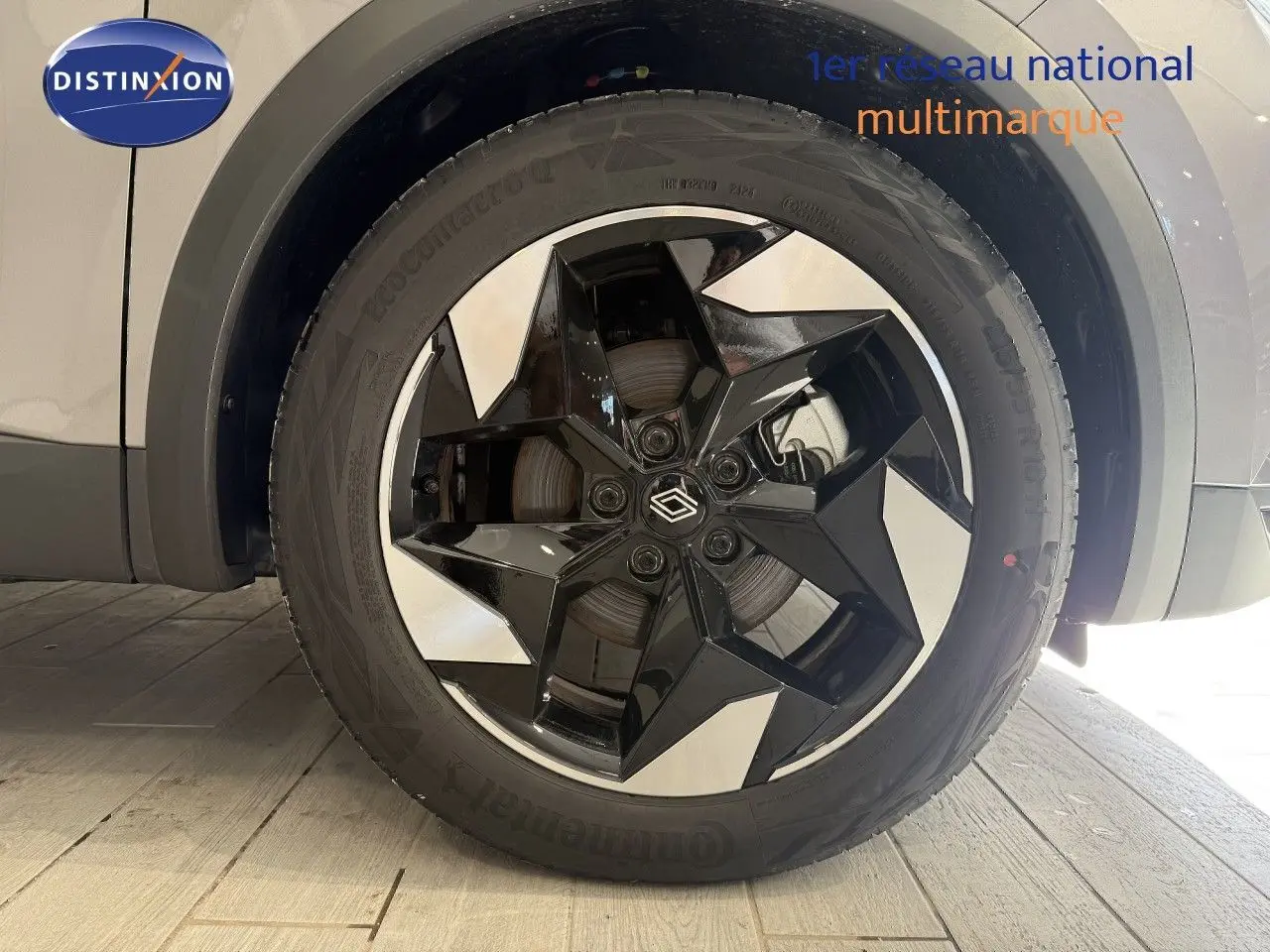 Gros plan sur la roue avant droite du Renault Captur gris Cassiopée avec jante noire et argentée au design géométrique.