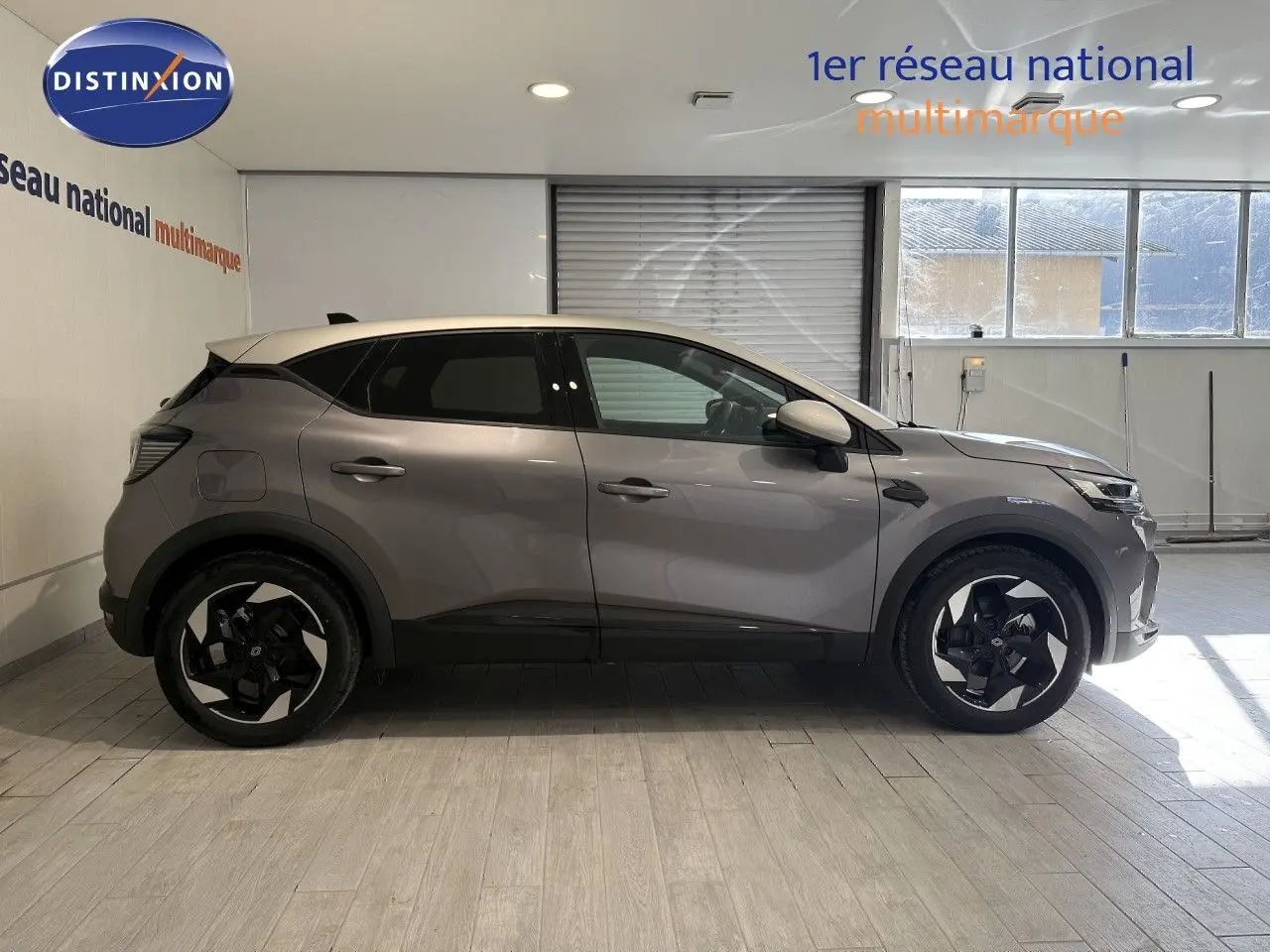 Profil droit du Renault Captur 2025 gris Cassiopée métal avec toit gris, jantes noires bicolores et vitres teintées.