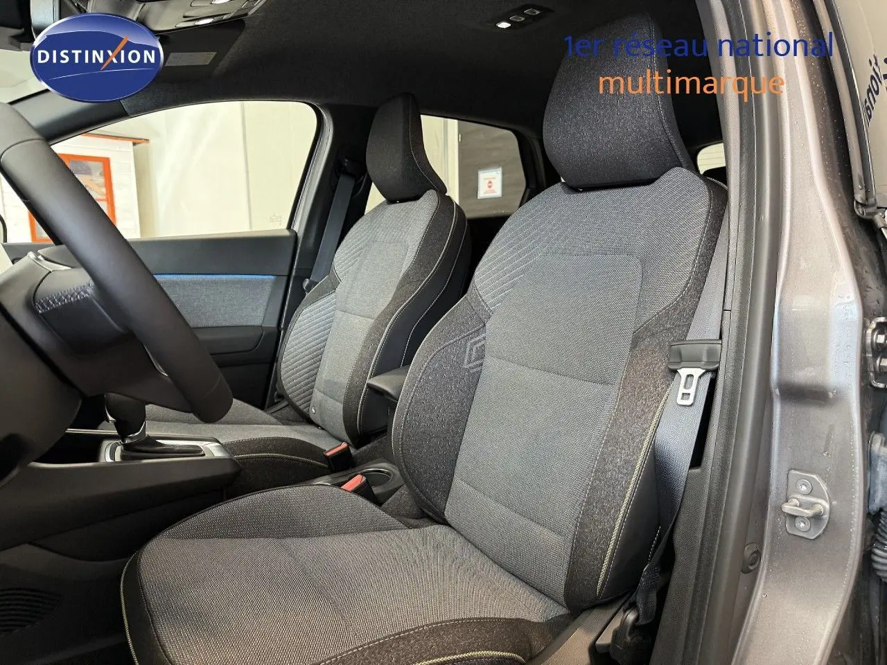 Vue intérieure côté droit du Renault Captur 2025 gris cassiopée, mettant en valeur les sièges tissu gris et noir.