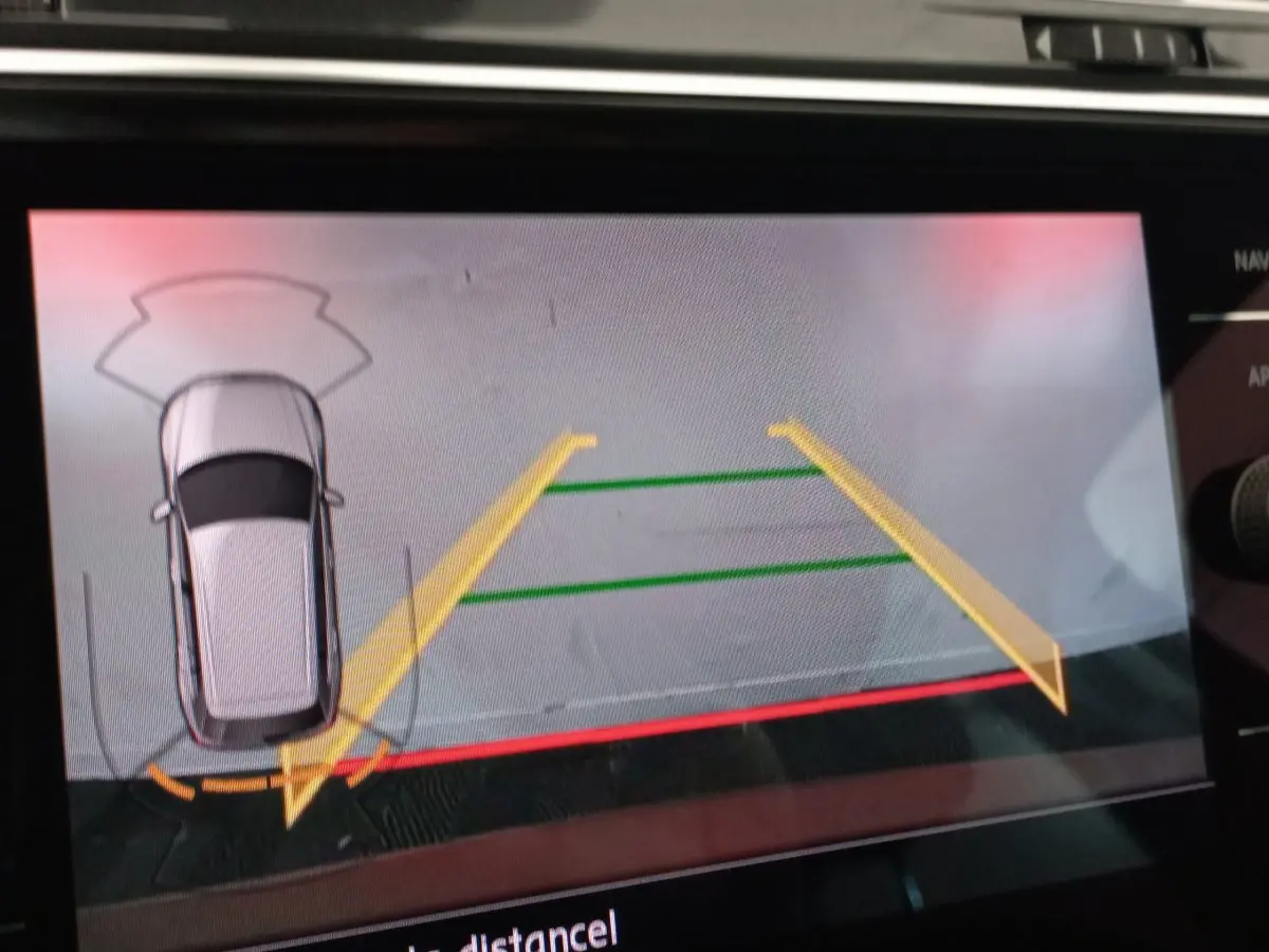 Affichage écran tactile montrant la caméra de recul du Volkswagen Tiguan Allspace marron en vue aérienne arrière.