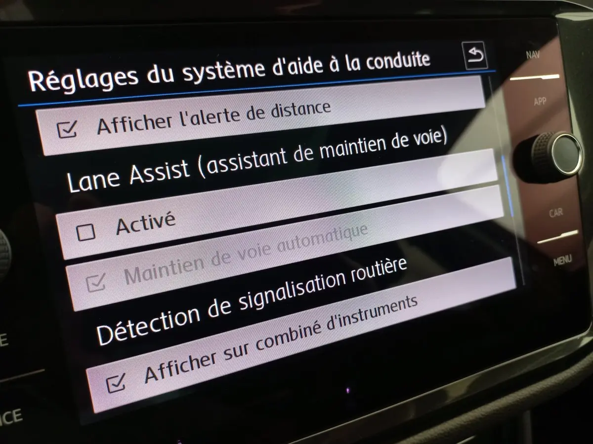 Écran tactile du système d'aide à la conduite du Volkswagen Tiguan Allspace, affichant les réglages Lane Assist et signalisation routière.