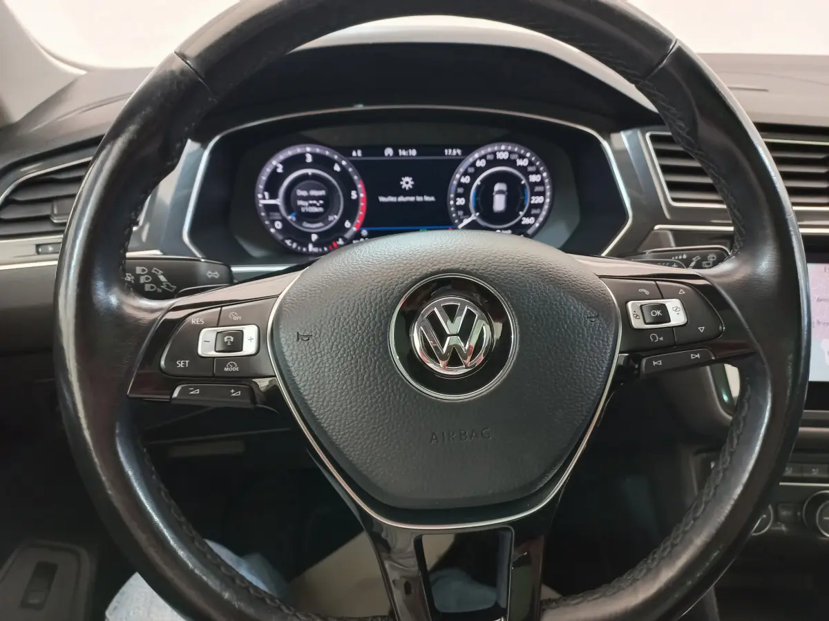 Vue rapprochée du volant cuir noir du Volkswagen Tiguan Allspace 2018 avec tableau de bord numérique allumé.