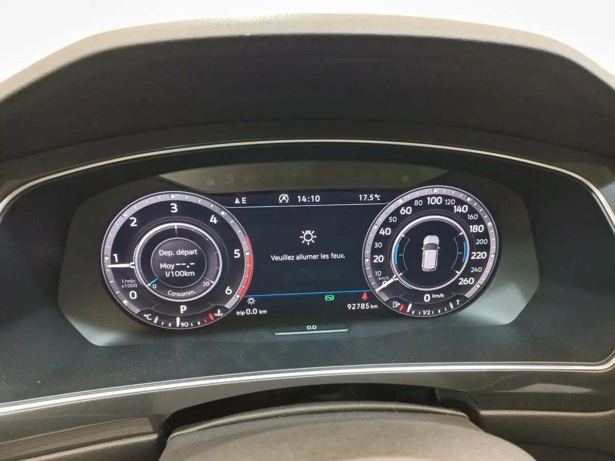 Tableau de bord numérique du Volkswagen Tiguan Allspace 2018 affichant la vitesse et la consommation, vue frontale rapprochée.