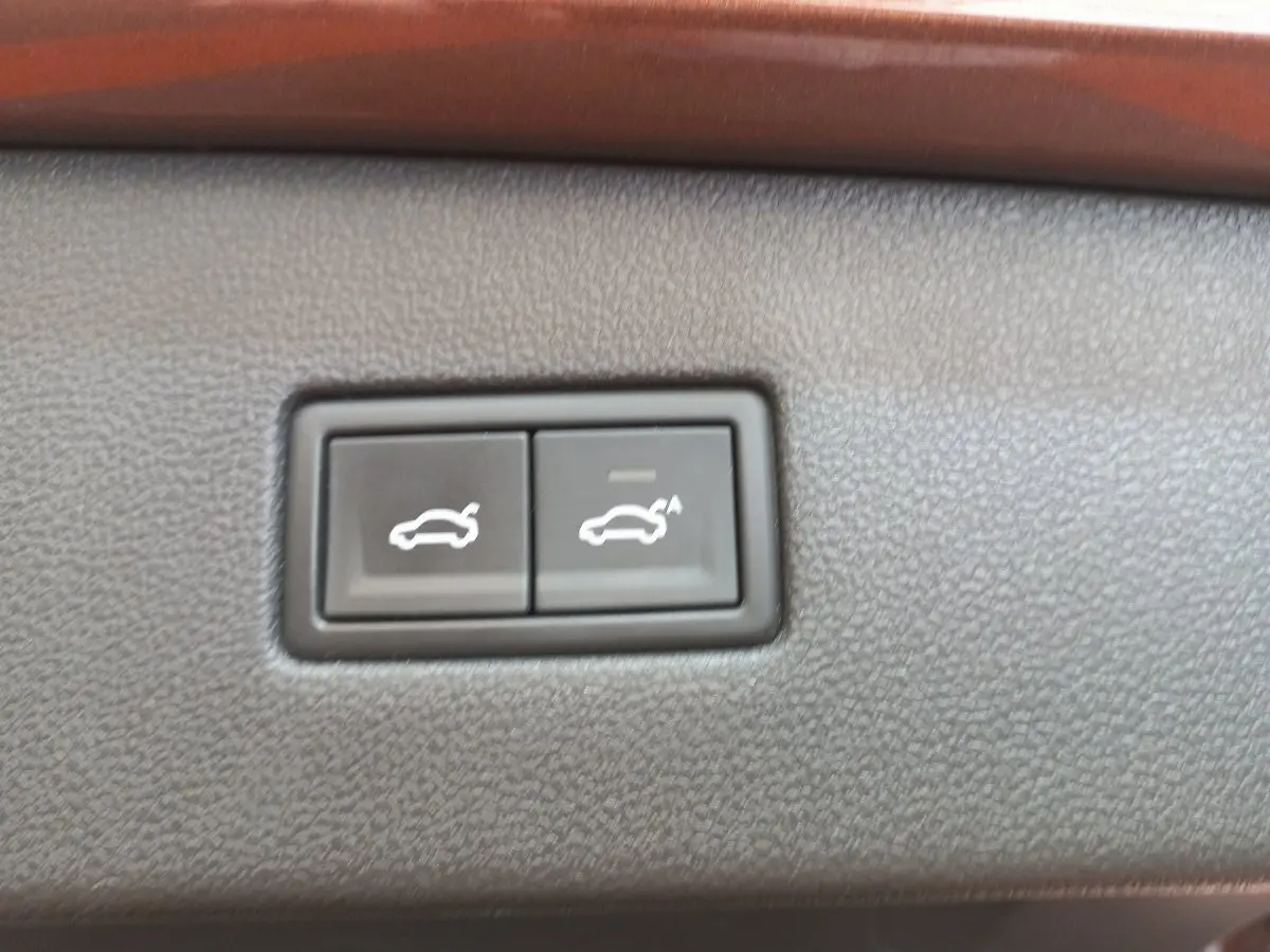 Gros plan sur les boutons d'ouverture et de fermeture électrique du coffre du Volkswagen Tiguan Allspace marron.