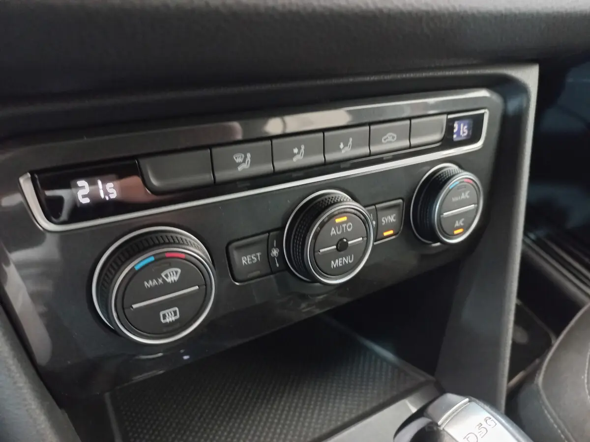 Gros plan sur la console centrale du Volkswagen Tiguan Allspace 2018, commandes de climatisation digitales et boutons noirs.