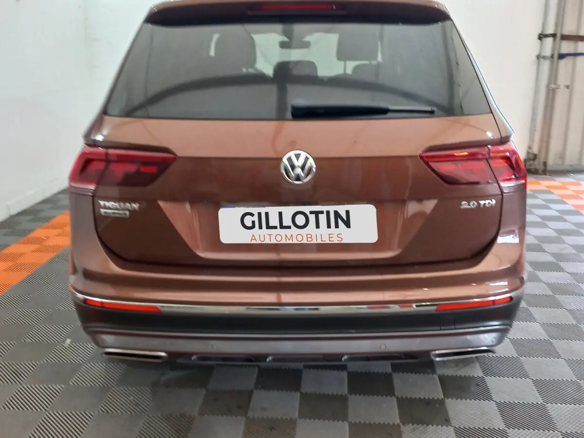 Vue arrière d'un Volkswagen Tiguan Allspace marron 2.0 TDI avec feux LED et double sortie d'échappement chromée.