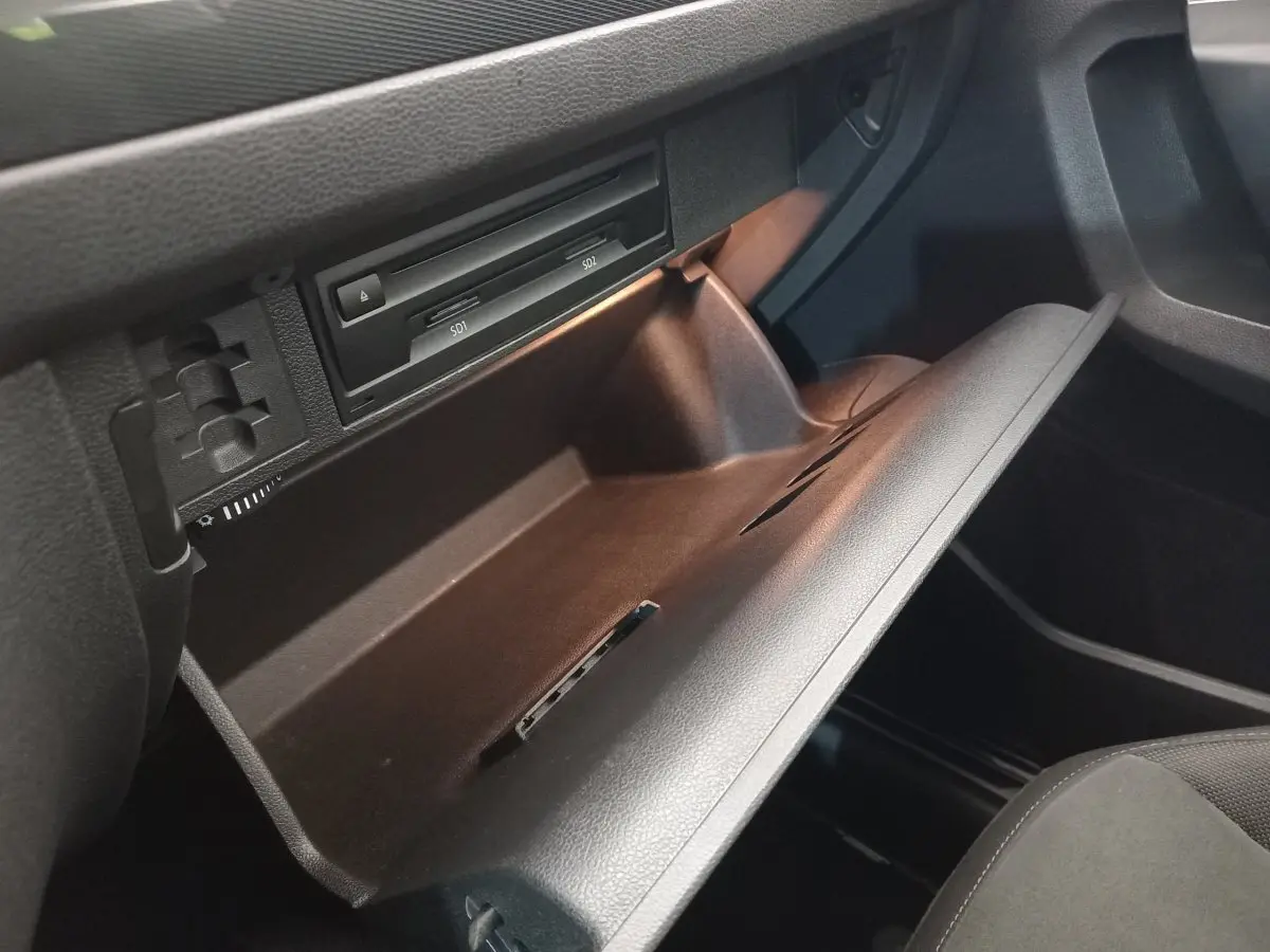 Gros plan sur la boîte à gants ouverte du Volkswagen Tiguan Allspace 2018, intérieur noir avec lecteur SD visible.
