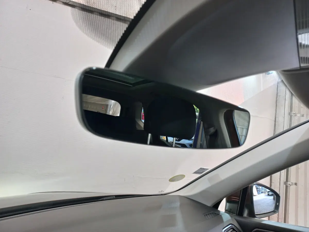 Vue intérieure du Volkswagen Tiguan Allspace 2018 marron, miroir intérieur et rétroviseur côté droit visibles.