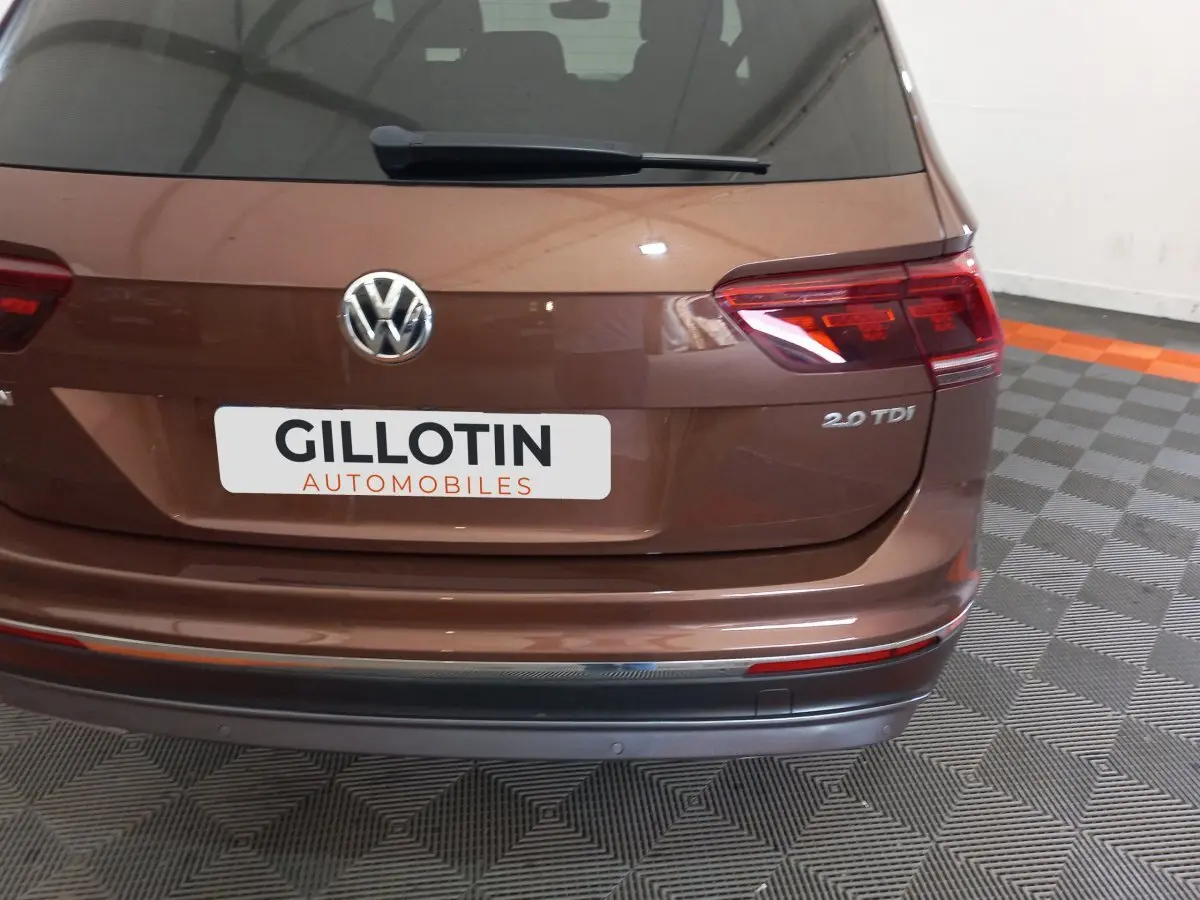 Vue arrière d'un Volkswagen Tiguan Allspace marron 2.0 TDI avec logo VW et feux arrière LED visibles