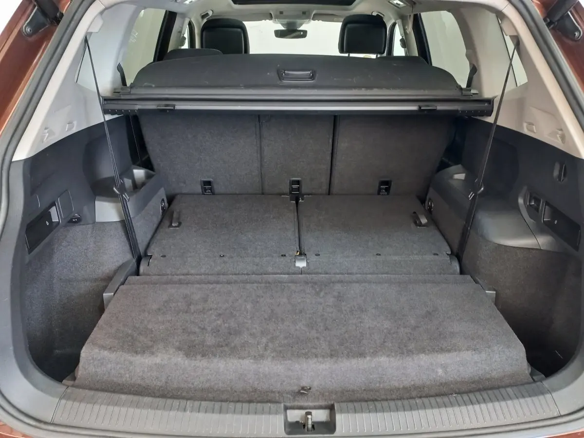 Coffre ouvert du Volkswagen Tiguan Allspace 2018, montrant la 3ème rangée rabattue et plancher plat intérieur gris.