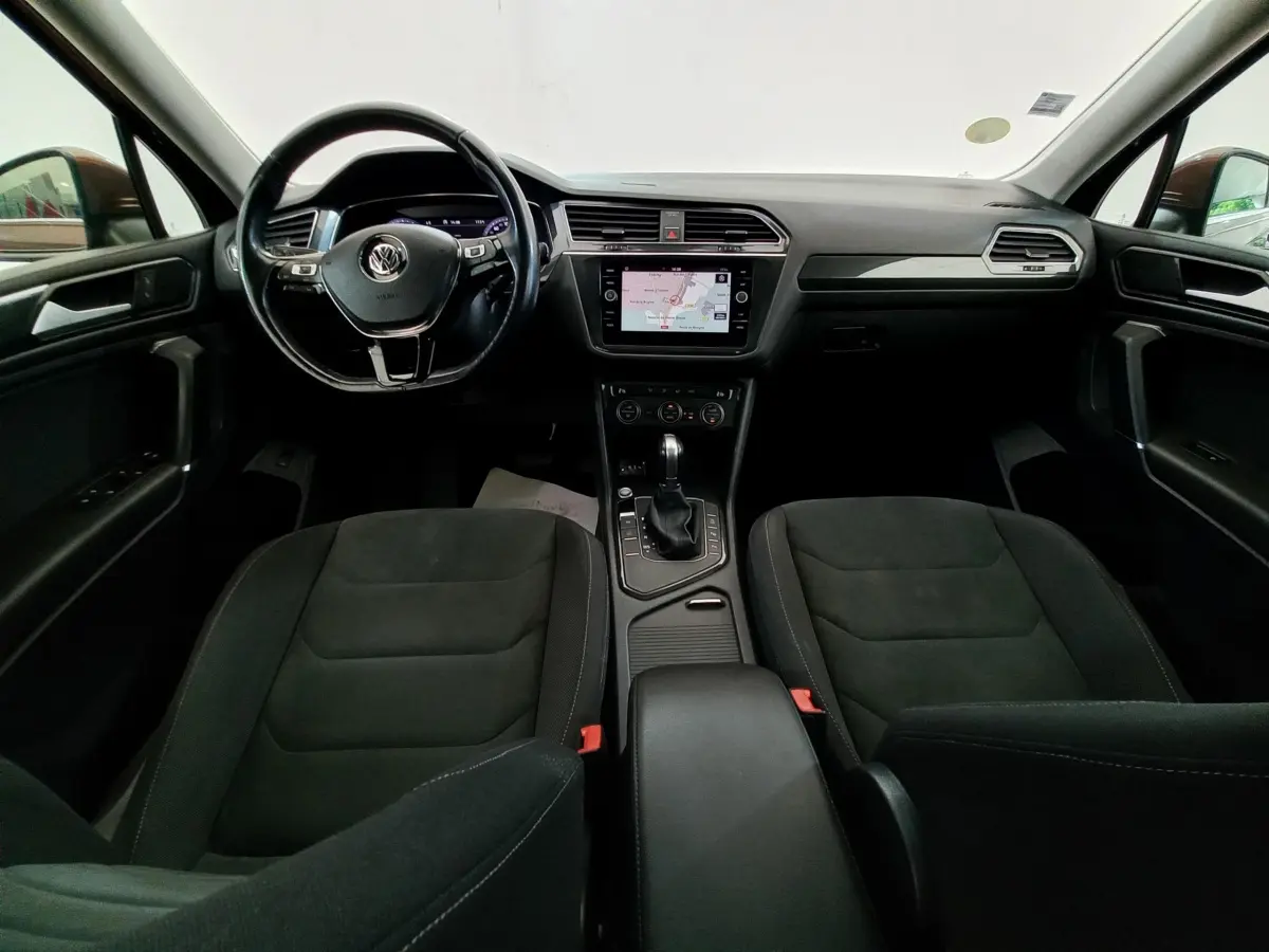Vue intérieure avant du Volkswagen Tiguan Allspace 2018 avec tableau de bord noir et écran tactile central affichant la navigation