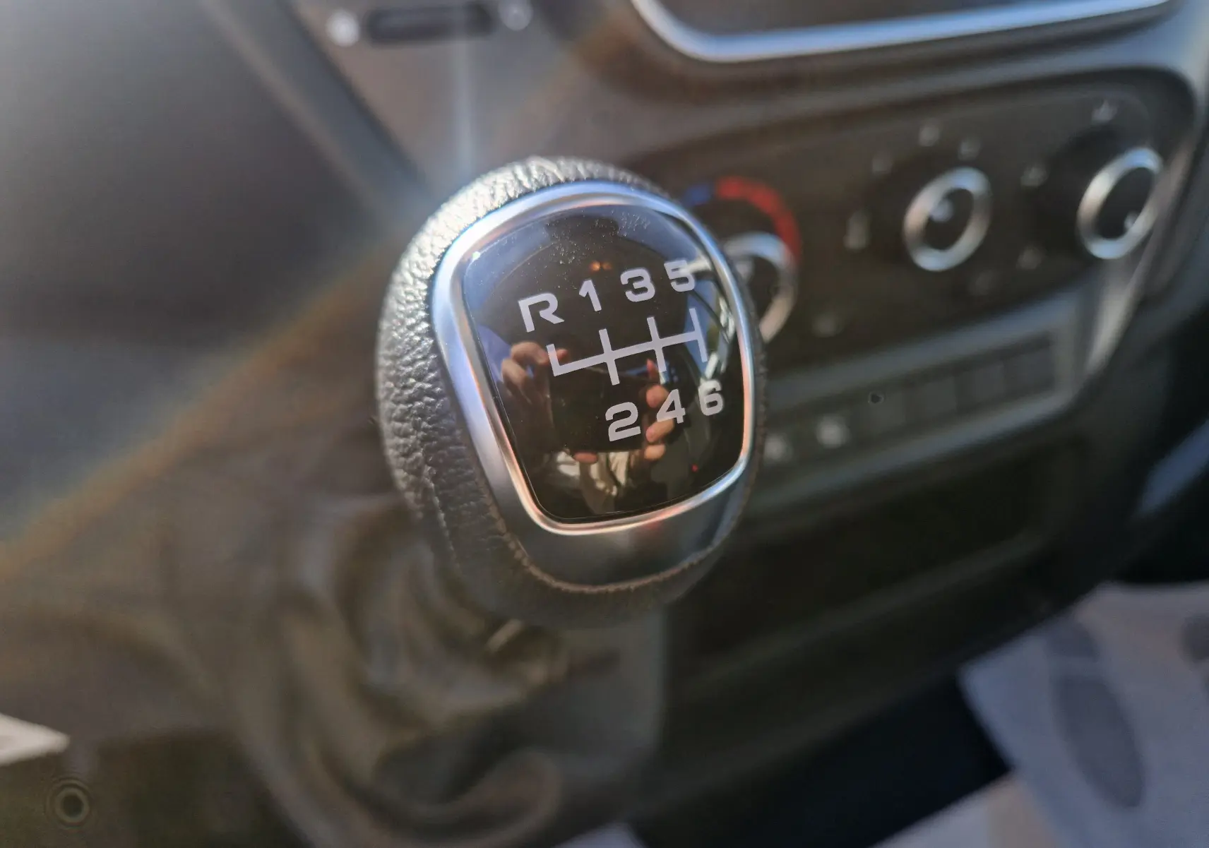 Gros plan sur le levier de vitesses manuel du Iveco Daily blanc, montrant les six rapports et la marche arrière.