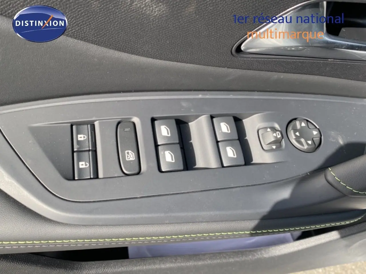 Détail des commandes de lève-vitres et rétroviseurs sur la porte côté gauche d’un Peugeot 308 blanc Okenite Metal.