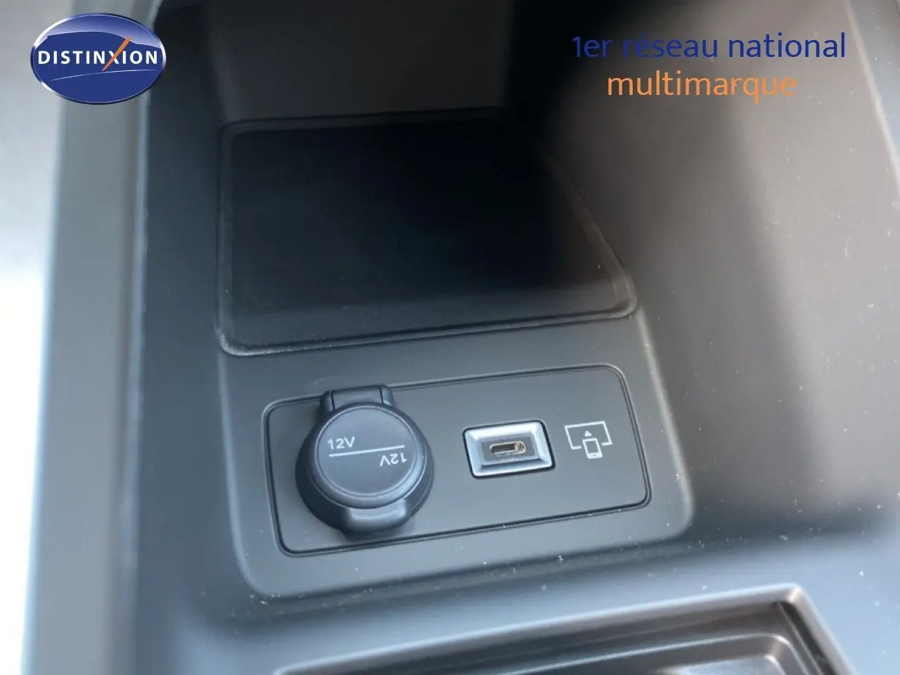 Prise 12V et port USB intégrés dans la console centrale d'une Peugeot 308 blanche, version hybride 2026.