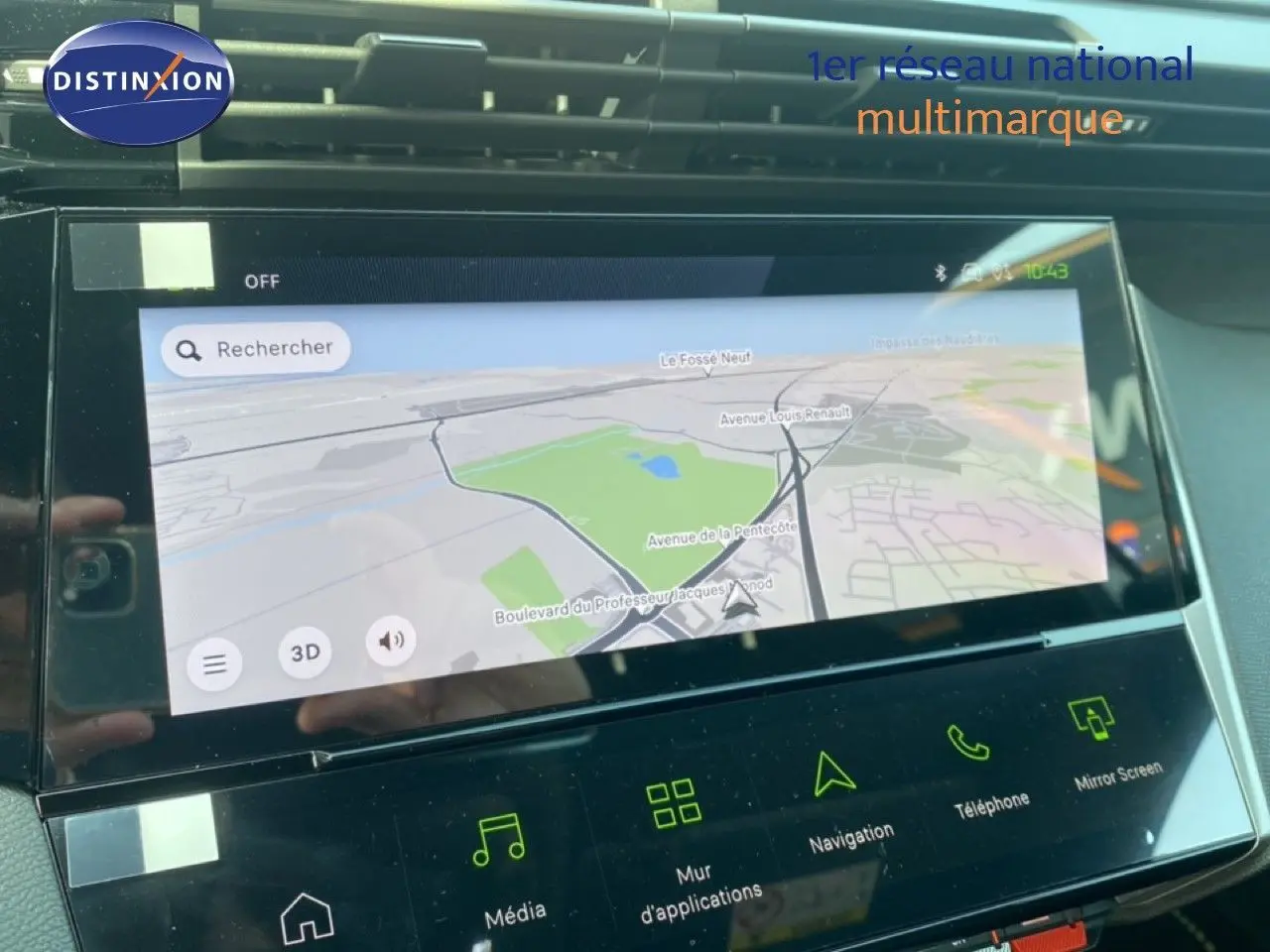Écran tactile central de la Peugeot 308 blanche, affichant la navigation GPS en vue carte, avec commandes tactiles en dessous.