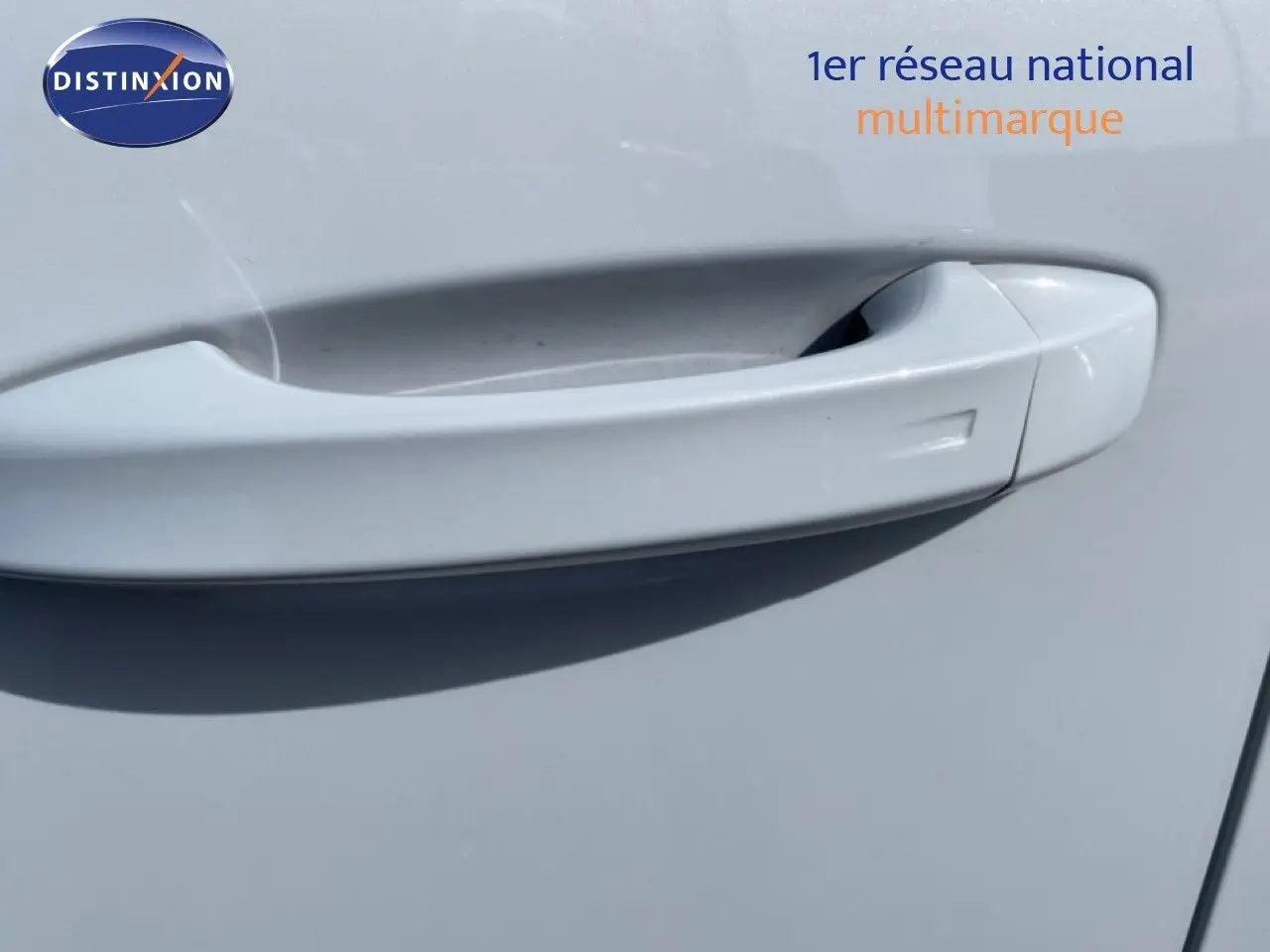 Poignée de porte blanche en gros plan sur une Peugeot 308 1.2 Hybrid 145ch GT, finition blanc Okenite métal.