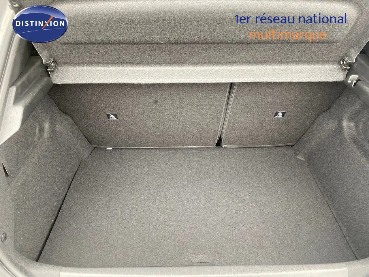 Coffre ouvert vu de face d'une Peugeot 208 Hybrid 110ch gris selenium metal, montrant un espace de chargement propre et spacieux.