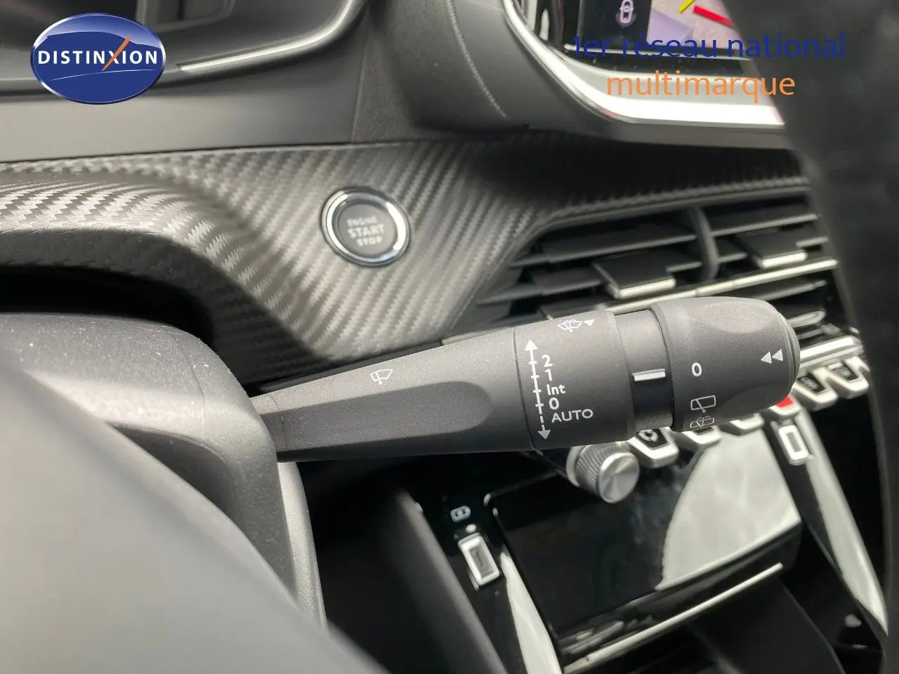 Gros plan sur la commande d’essuie-glace à gauche du volant dans l’habitacle gris et noir d’une Peugeot 208 Hybrid 110ch 2026.