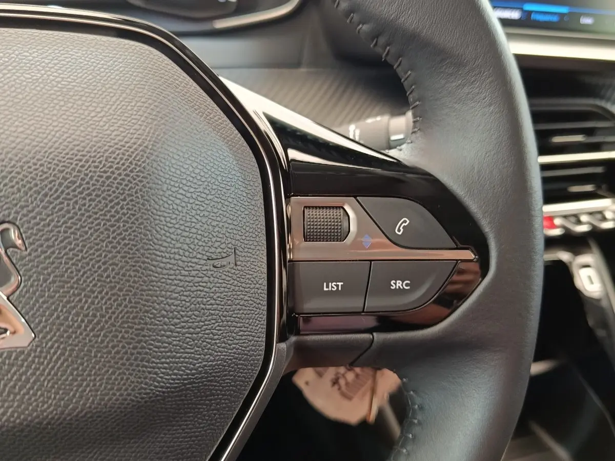 Gros plan sur les commandes multifonctions à droite du volant cuir noir du Peugeot 208 PureTech 75 S&S Style 2023.