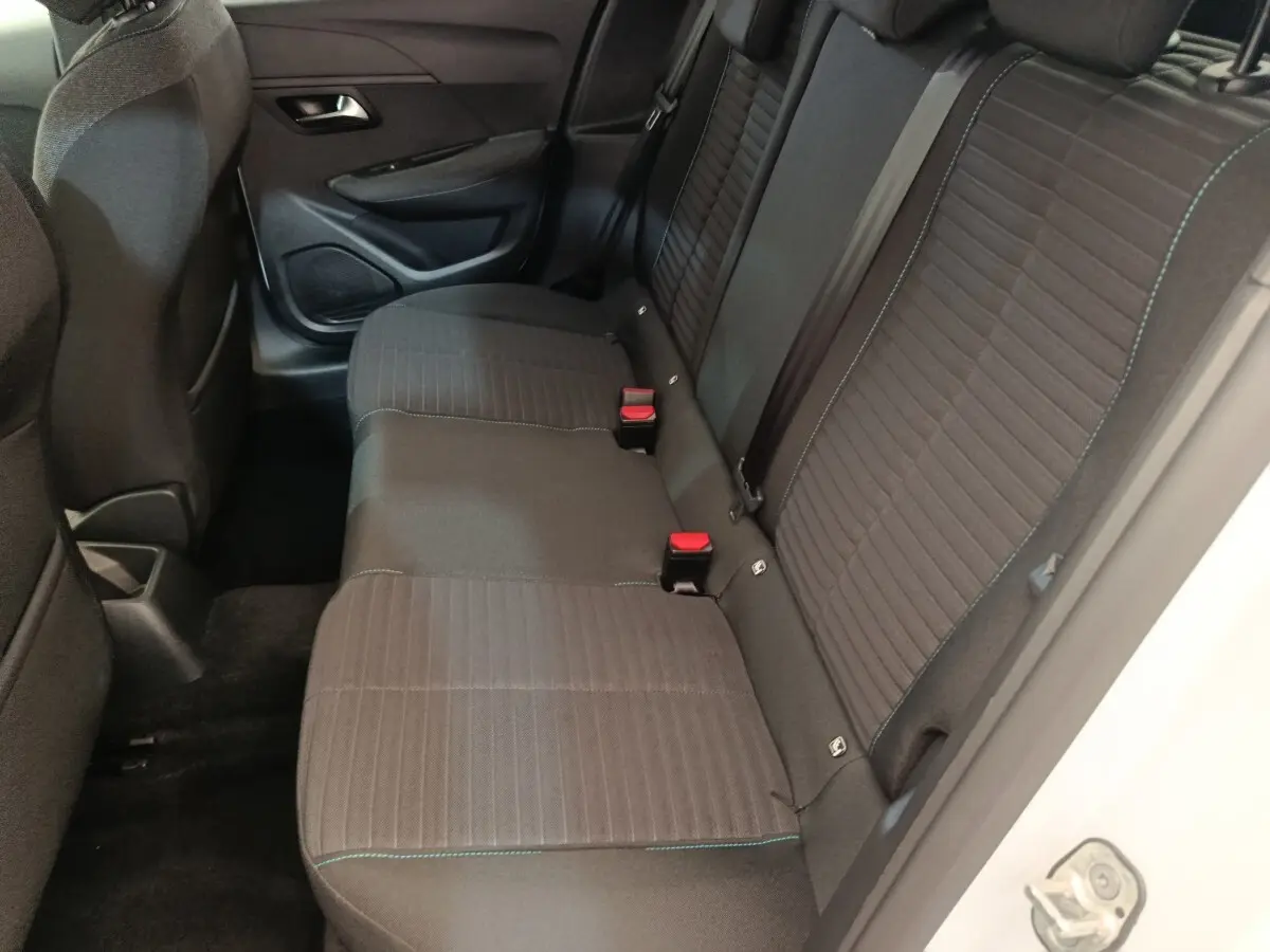 Vue intérieure côté droit sur la banquette arrière noire avec surpiqûres bleues d'une Peugeot 208 2023 PureTech Style.