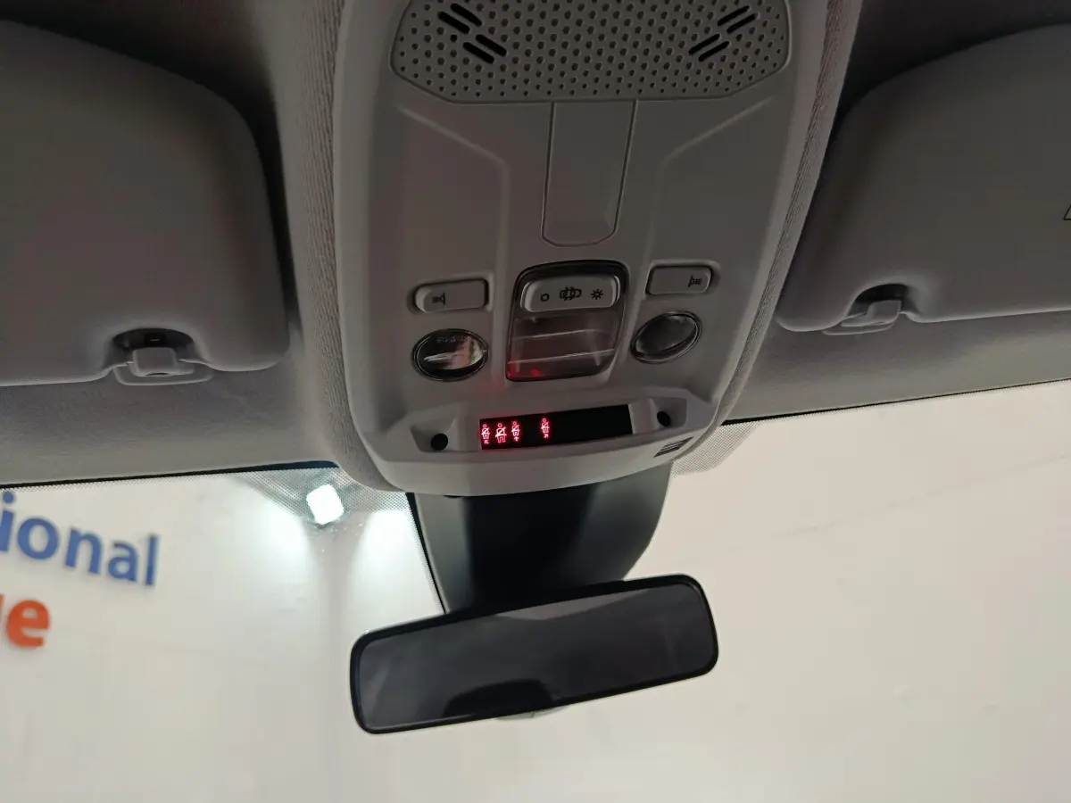 Vue intérieure centrée sur le plafonnier et le rétroviseur intérieur d'une Peugeot 208 2023, éclairage et commandes visibles.