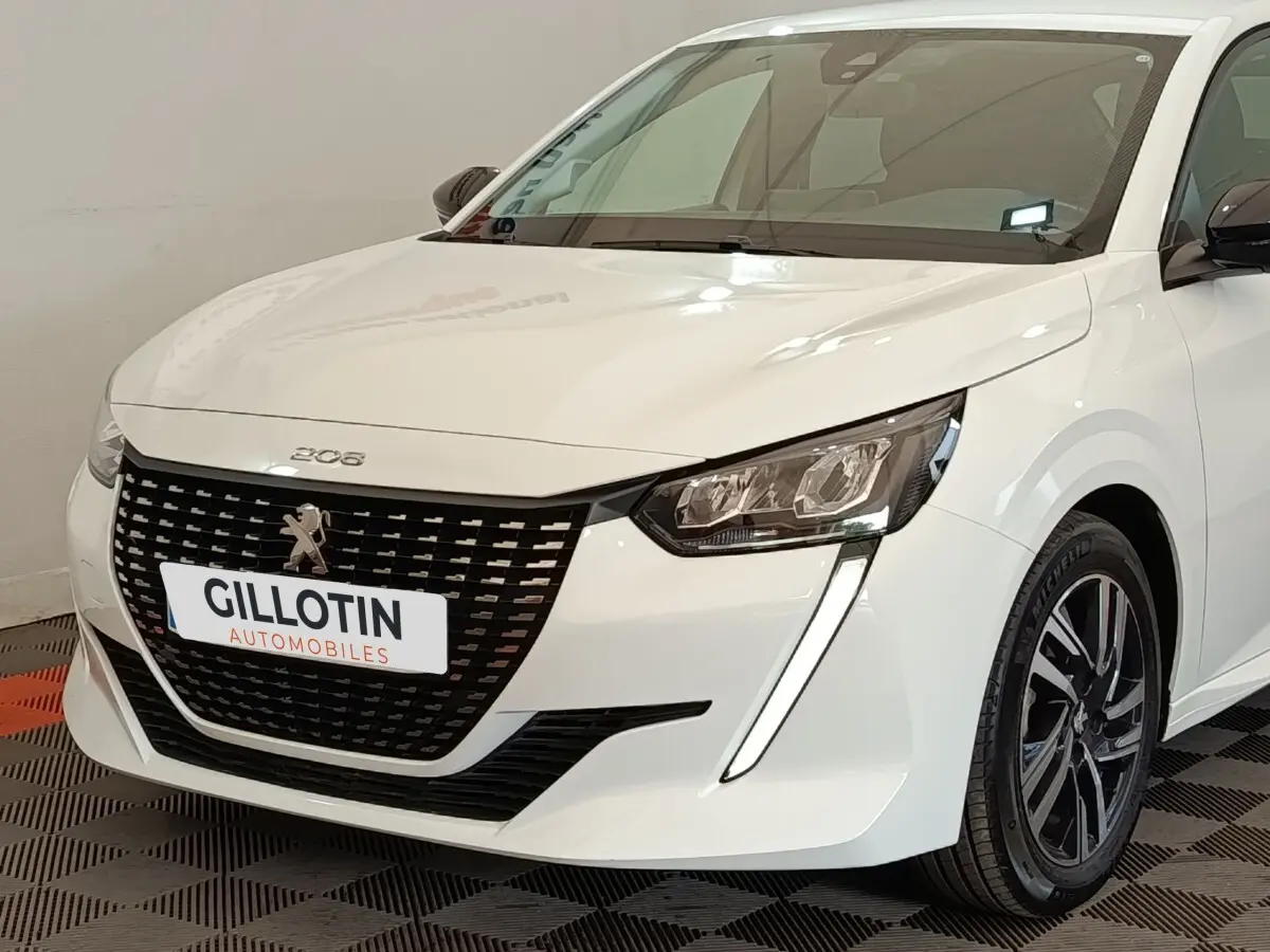Peugeot 208 PureTech 75 S&S Style blanche vue 3/4 avant droit, avec calandre noire et feux LED distinctifs.