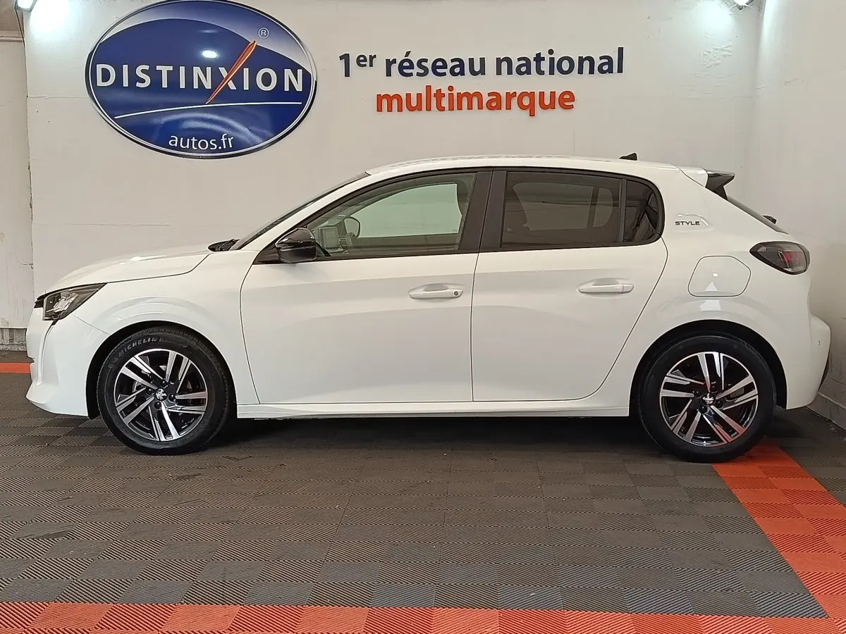 Profil côté gauche d'une Peugeot 208 PureTech 75 S&S Style blanche, avec jantes alliage et logo Style sur l'aile arrière.
