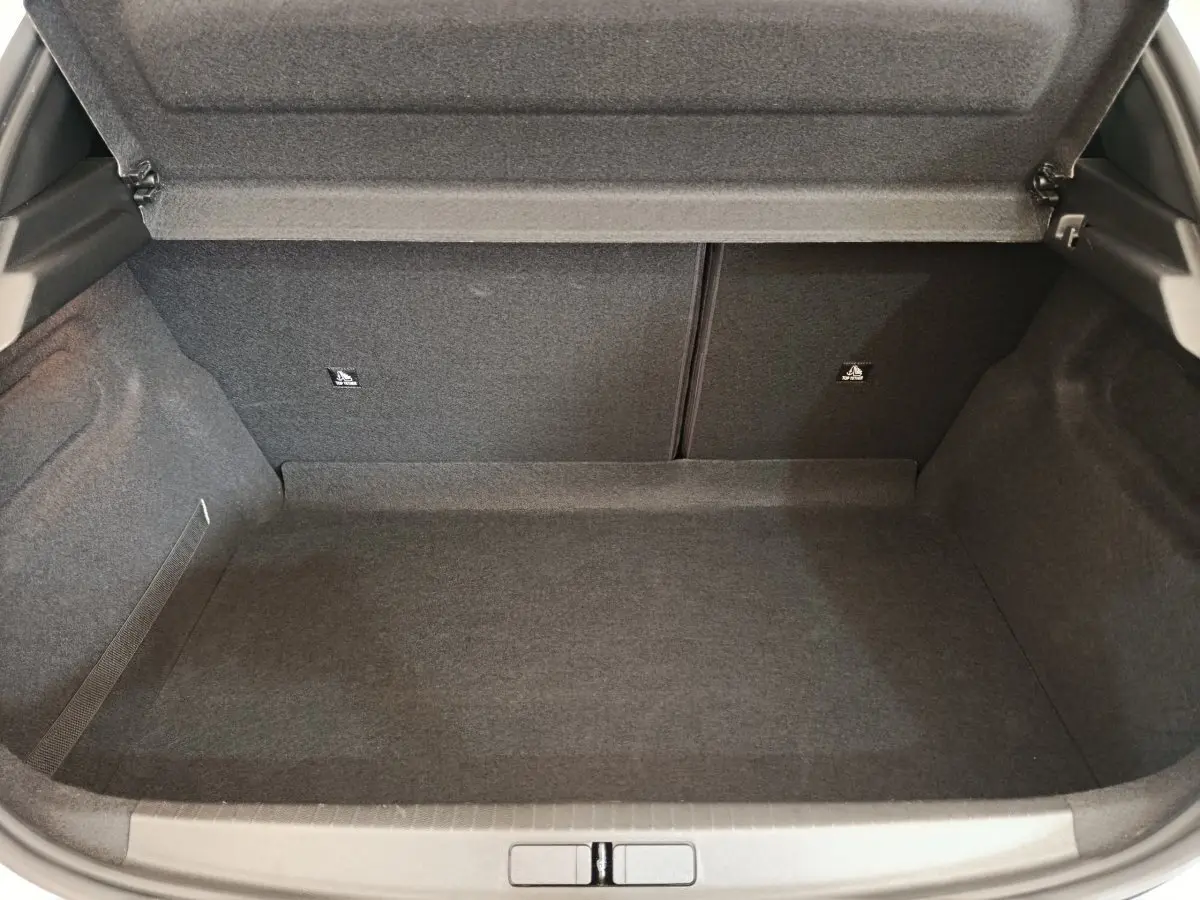 Coffre ouvert vu de face de la Peugeot 208 PureTech 75 S&S Style 2023, revêtement intérieur gris foncé.