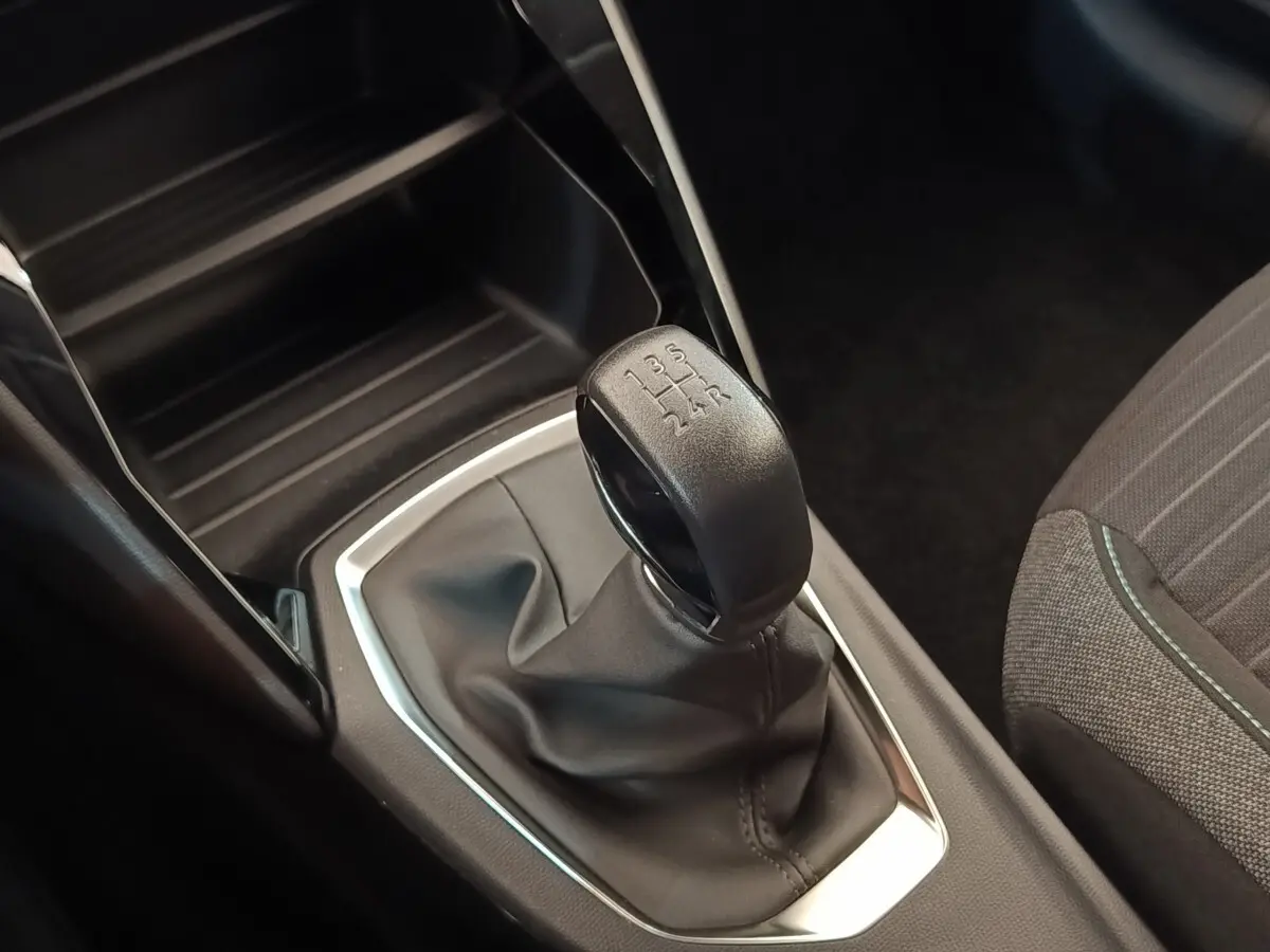 Gros plan sur le levier de vitesses manuel noir de la Peugeot 208 PureTech 75 S&S Style, intérieur gris.