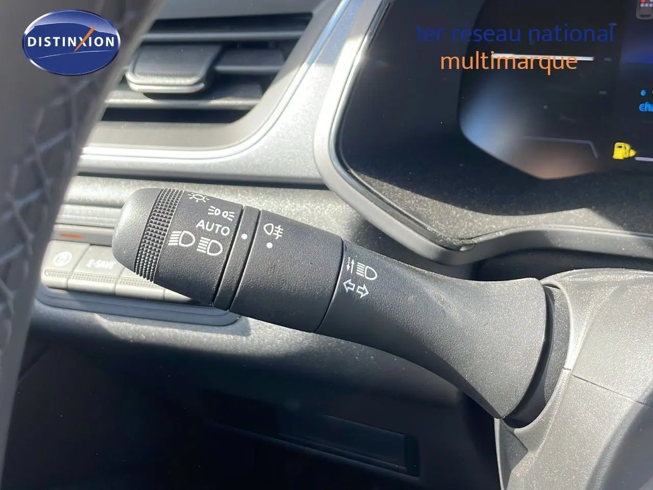 Gros plan sur la commande des phares et clignotants à gauche du volant dans l’habitacle du Renault Captur noir étoile métal.