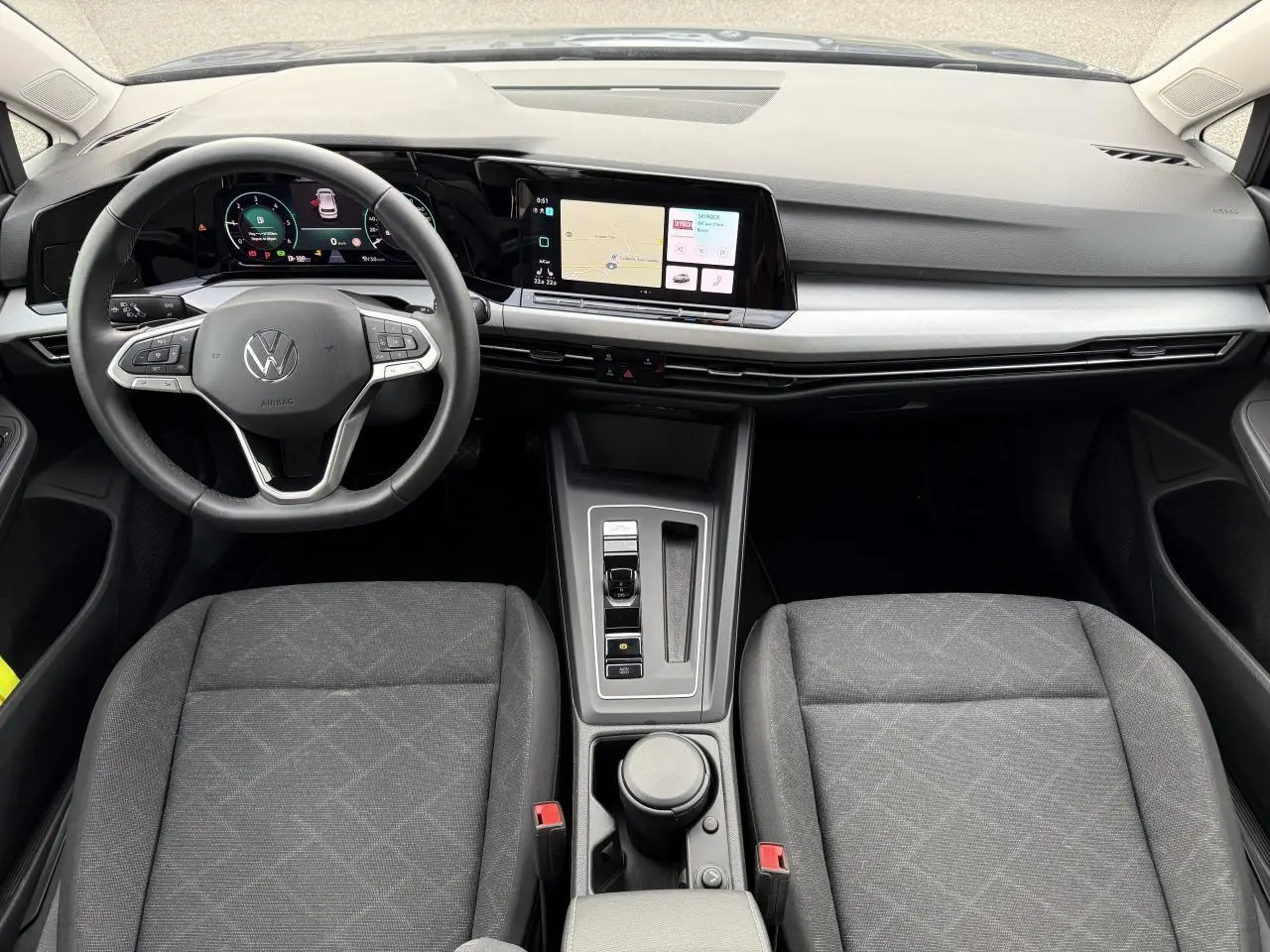 Vue intérieure avant de la Volkswagen Golf 2023 montrant le tableau de bord digital et la console centrale moderne.