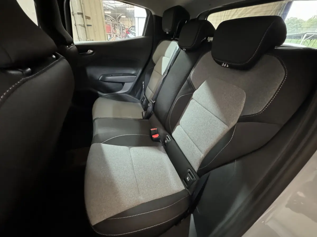 Vue intérieure côté droit sur la banquette arrière bicolore gris clair et noir de la Renault Clio 2025 Evolution Blue dCi 100.