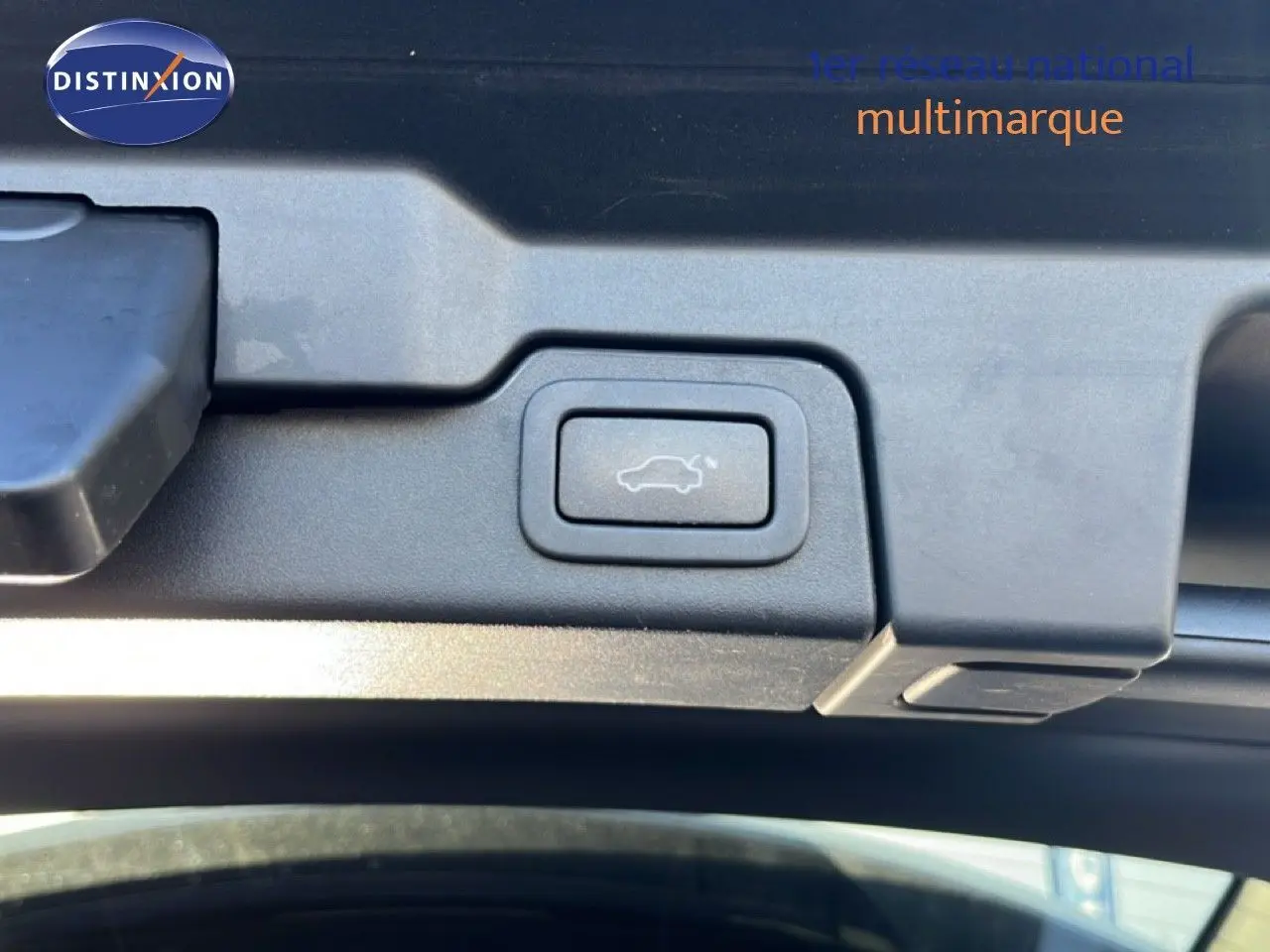 Bouton d'ouverture électrique du hayon sur un Range Rover Evoque blanc, vue en gros plan intérieur du coffre.