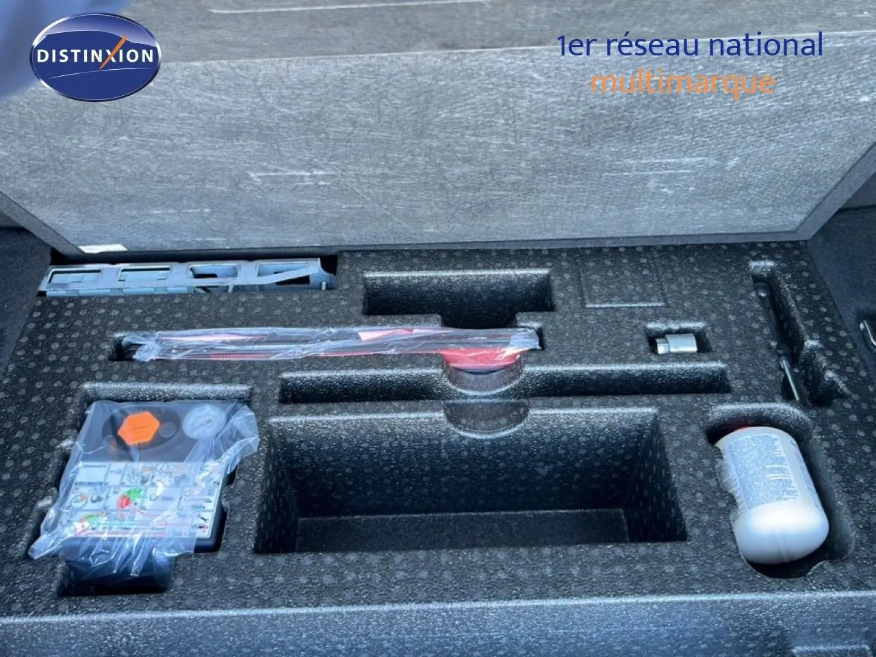 Compartiment de rangement dans le coffre d'un Range Rover Evoque blanc 2017, montrant les outils et accessoires d'origine.