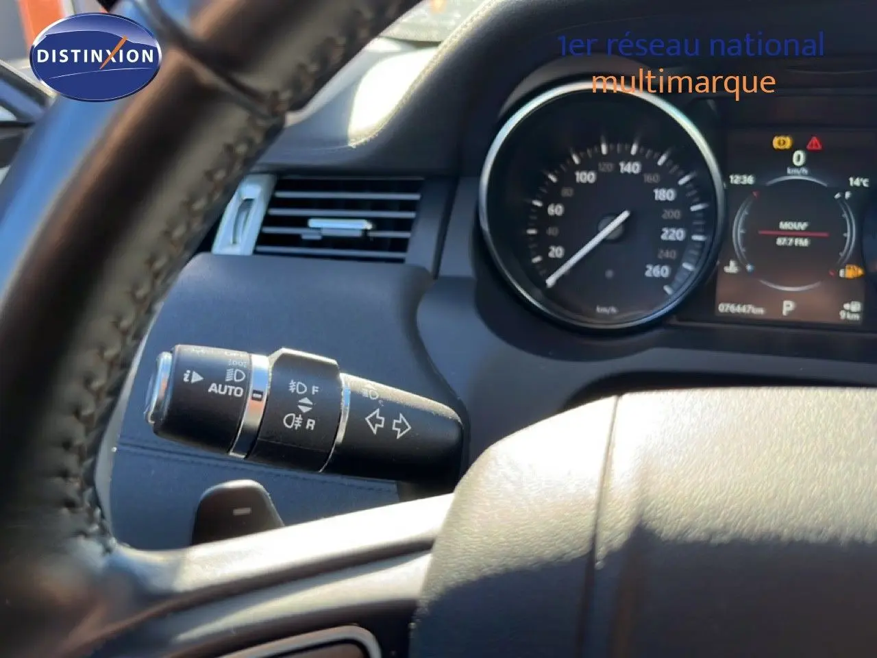 Vue rapprochée du volant et du commodo gauche du tableau de bord d'un Range Rover Evoque blanc de 2017.