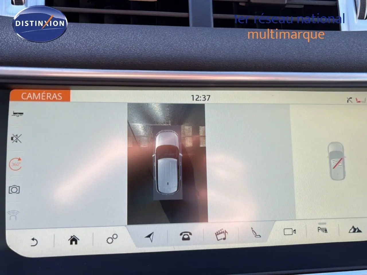 Vue aérienne sur l'écran de la caméra 360 du Range Rover Evoque blanc montrant le véhicule en stationnement.